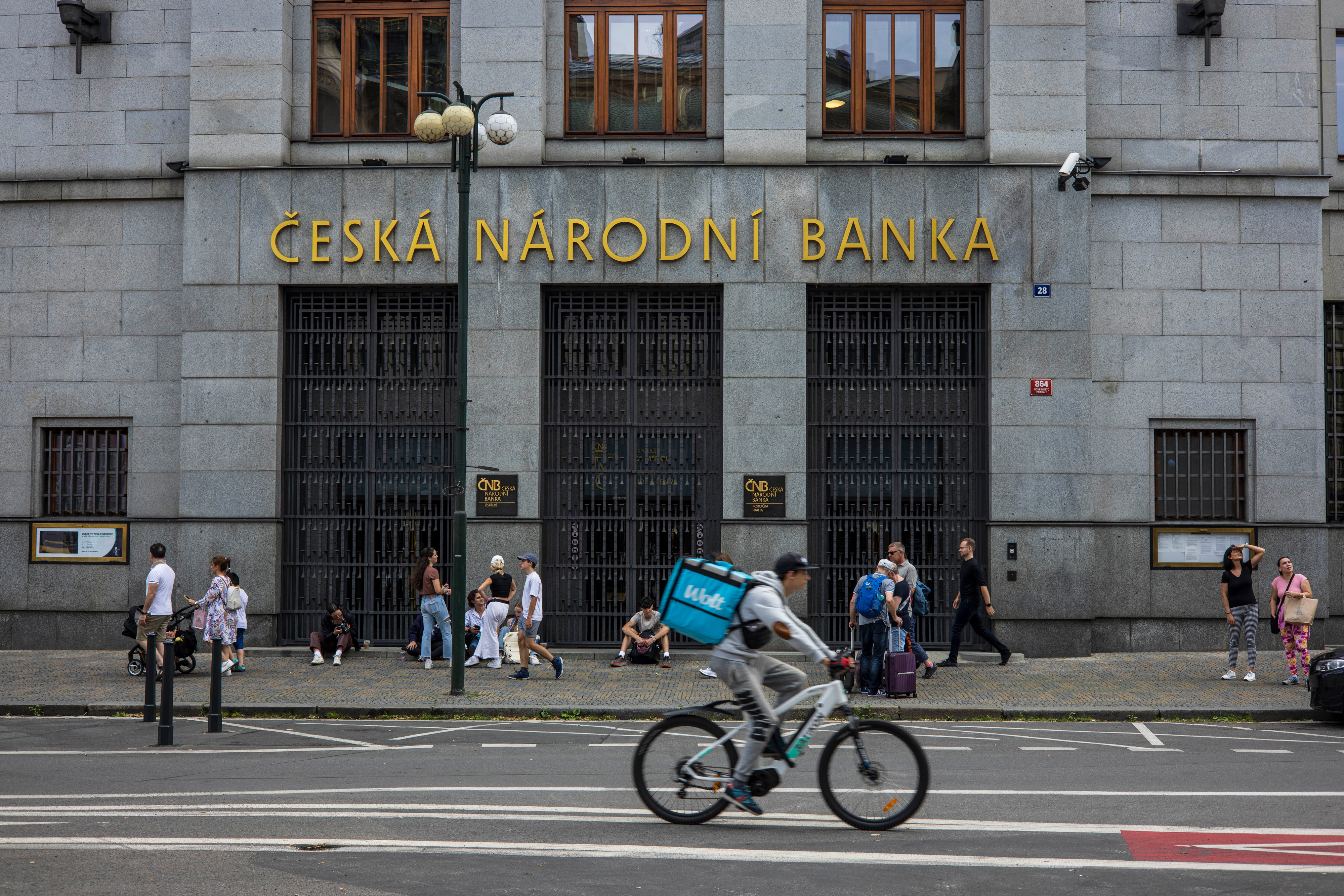 a cyclist rides by a building in prague