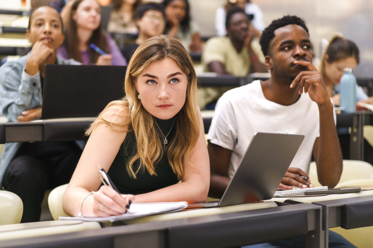 students take notes in a lecture hall
