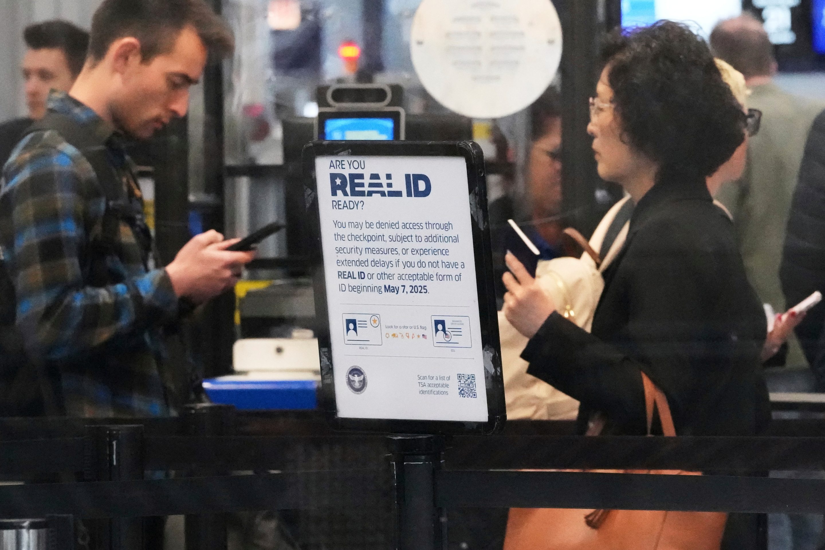 A Real ID sign is displayed as travelers wait to go through security check point at O'Hare International Airport in Chicago, May 23, 2025.