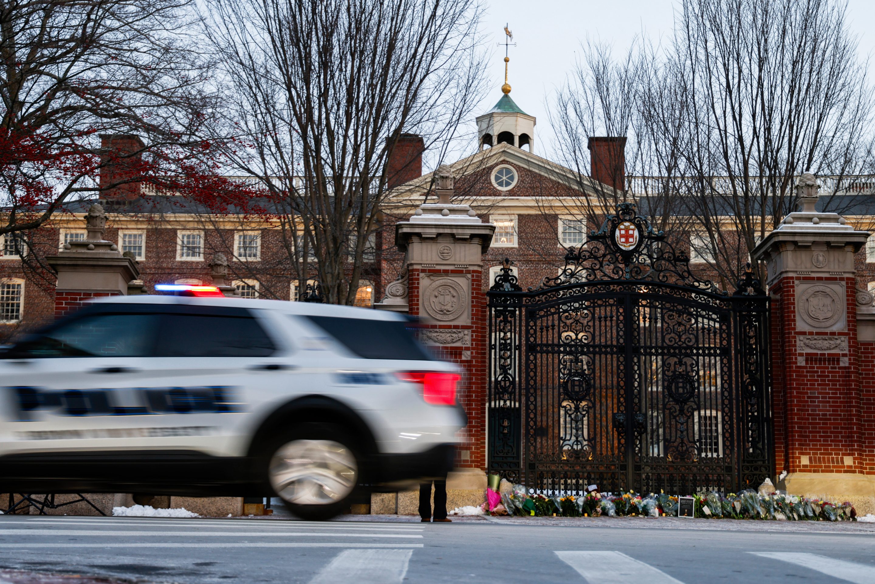 A Providence police car passes by Brown University's Van Wickle gates, in Providence, R.I., two days after a shooting took place on Brown University's campus, Monday, Dec. 15, 2025.