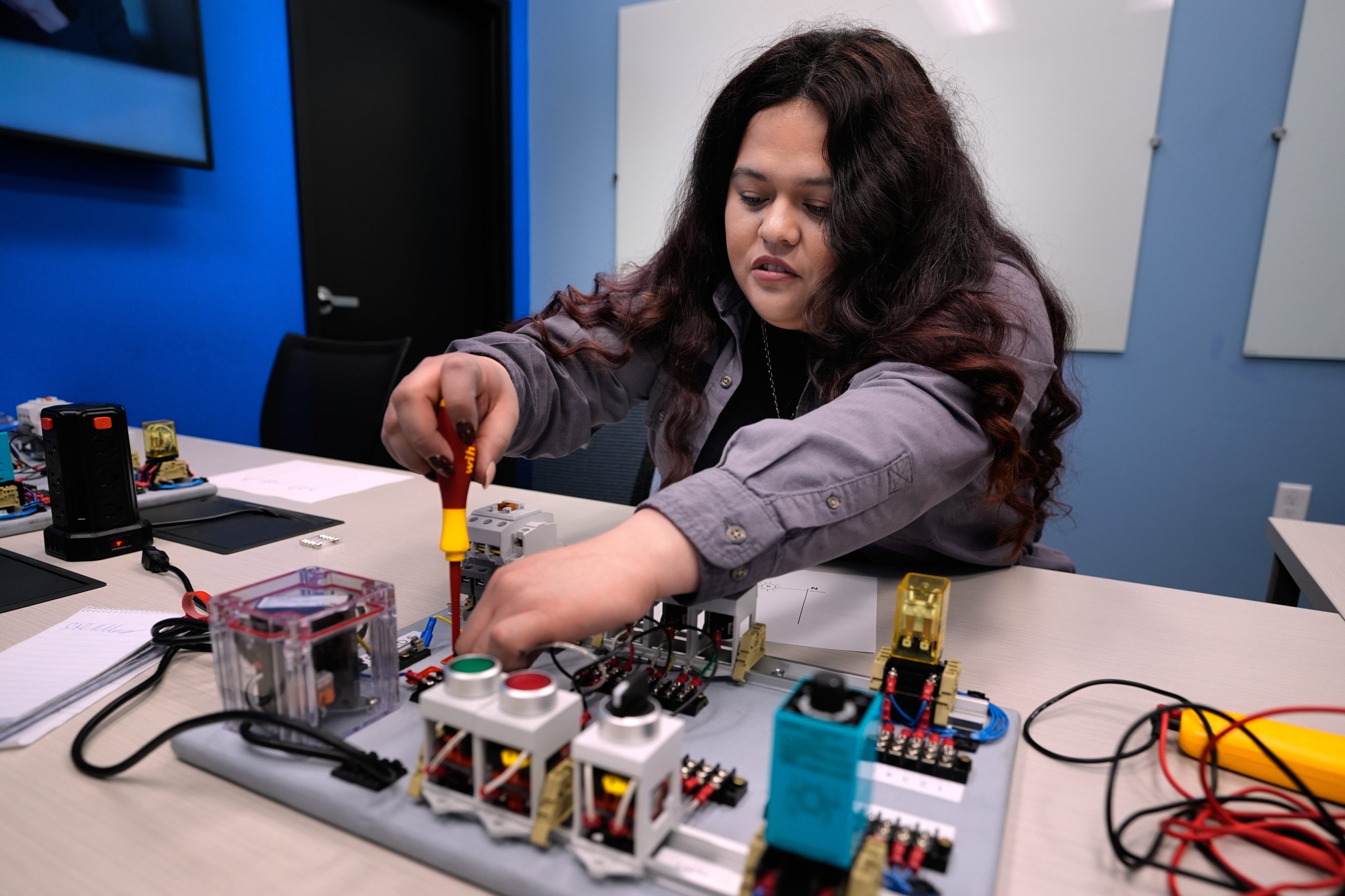 Maintenance technician Liz Cardenas completes a task on an electronics test platform at a training area in a Walmart distribution center Thursday, Sept. 25, 2025, in Bentonville, Ark.