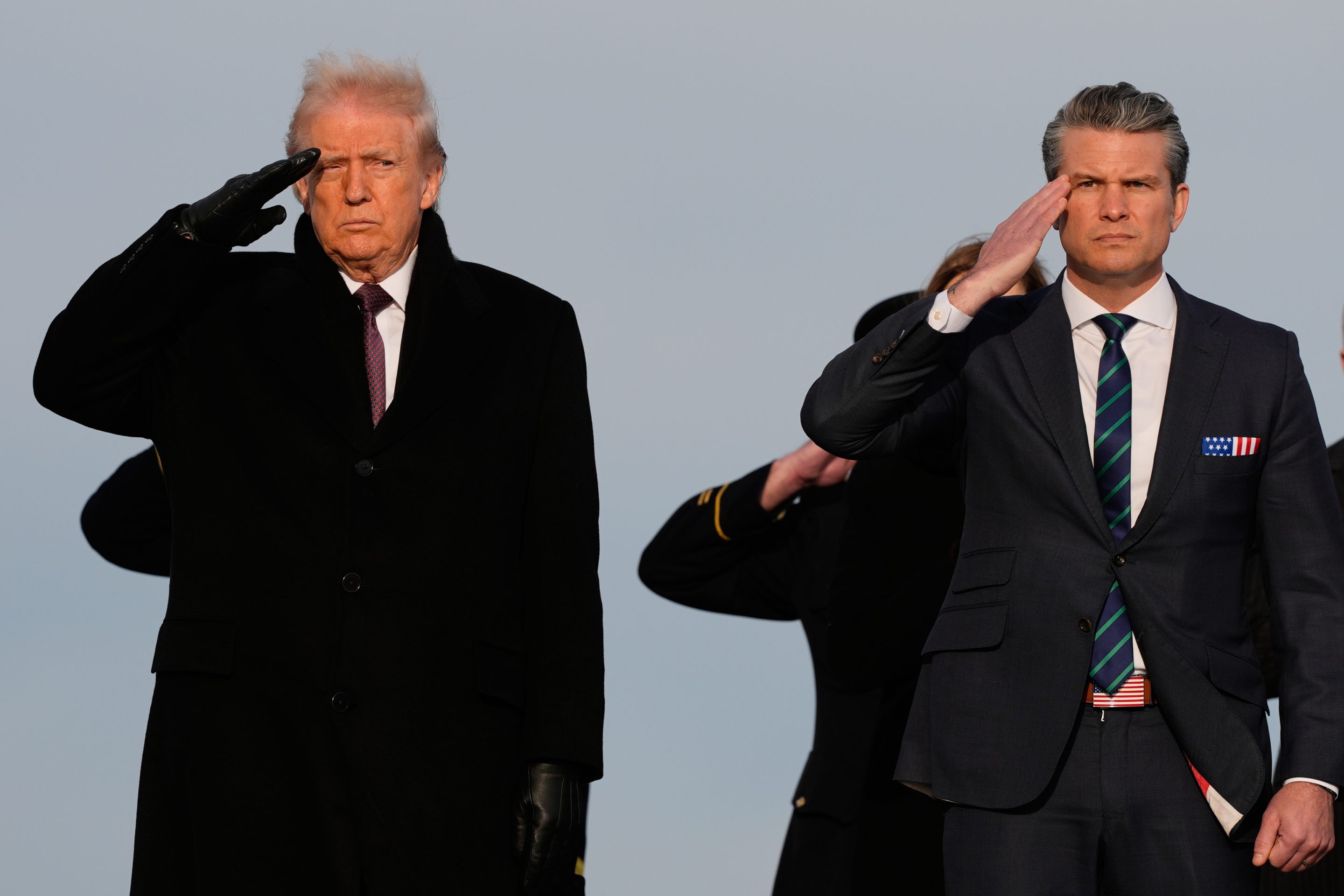 President Donald Trump and Defense Secretary Pete Hegseth salute during a casualty return, Wednesday, Dec. 17, 2025 at Dover Air Force Base, Del.