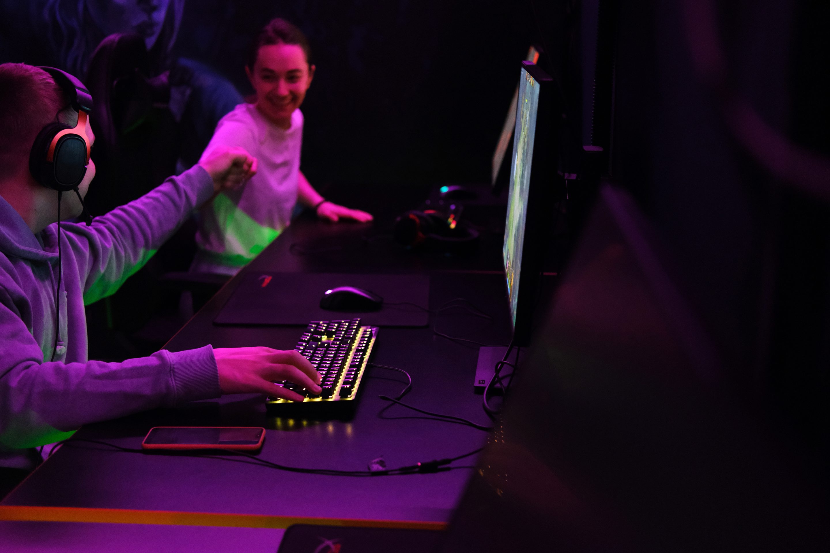 Two gamer teenagers work on computers.