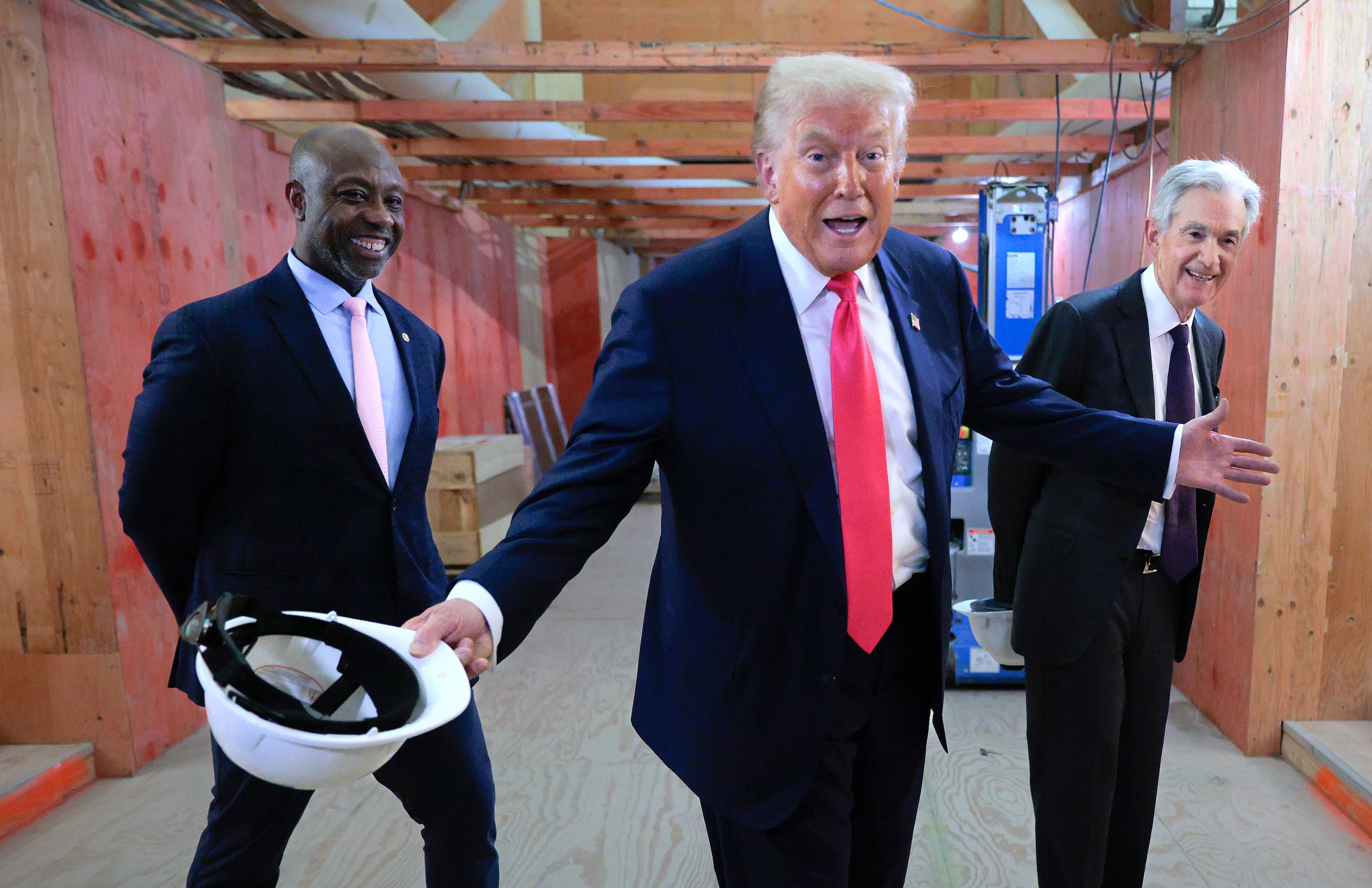 From left: U.S. Sen. Tim Scott, President Donald Trump, and Federal Reserve Chair Jerome Powell tour the Federal Reserve’s headquarters renovation project, July 24, 2025.