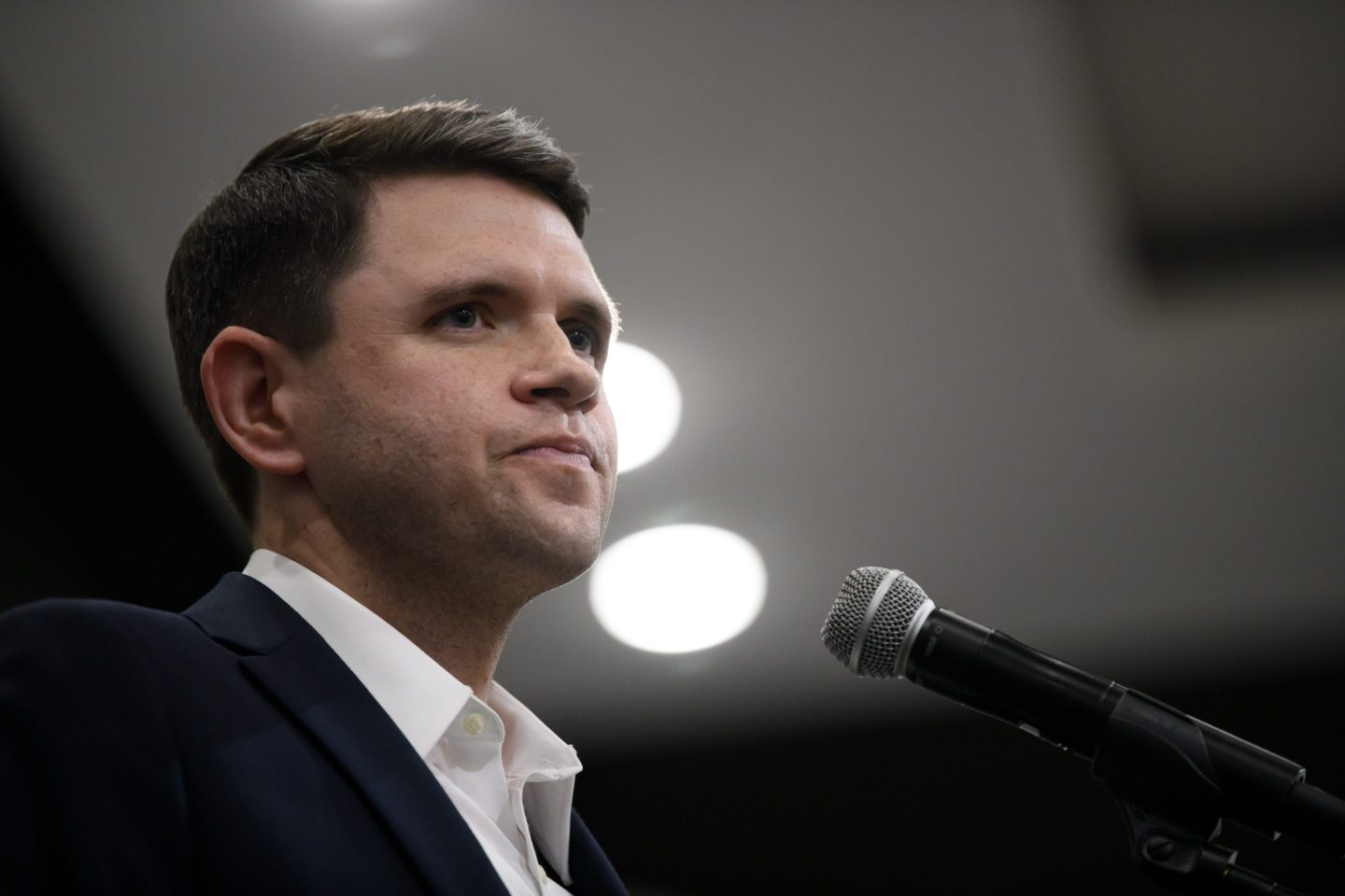 James Talarico stands behind a microphone and stares out into the crowd