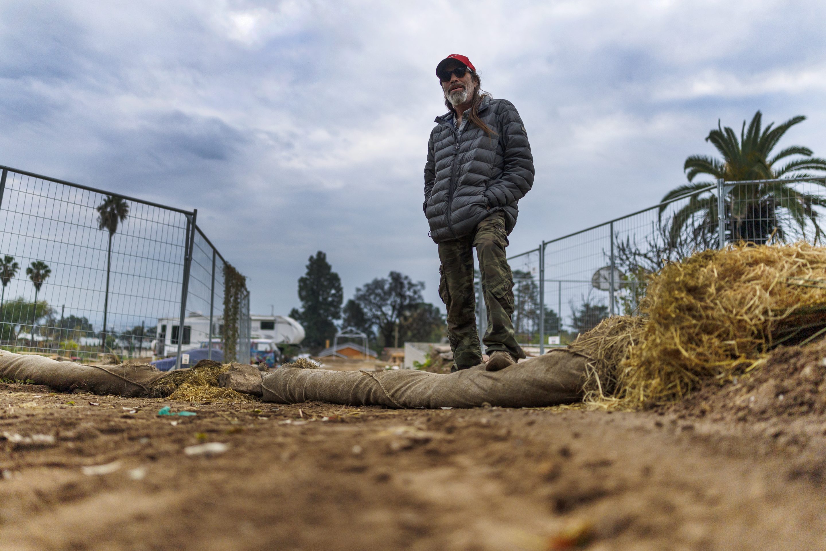 Dave Racs of Altadena placed large hay filled burlap rolls around his property to keep mud and debris from flowing onto his property once the forecasted storm hits.