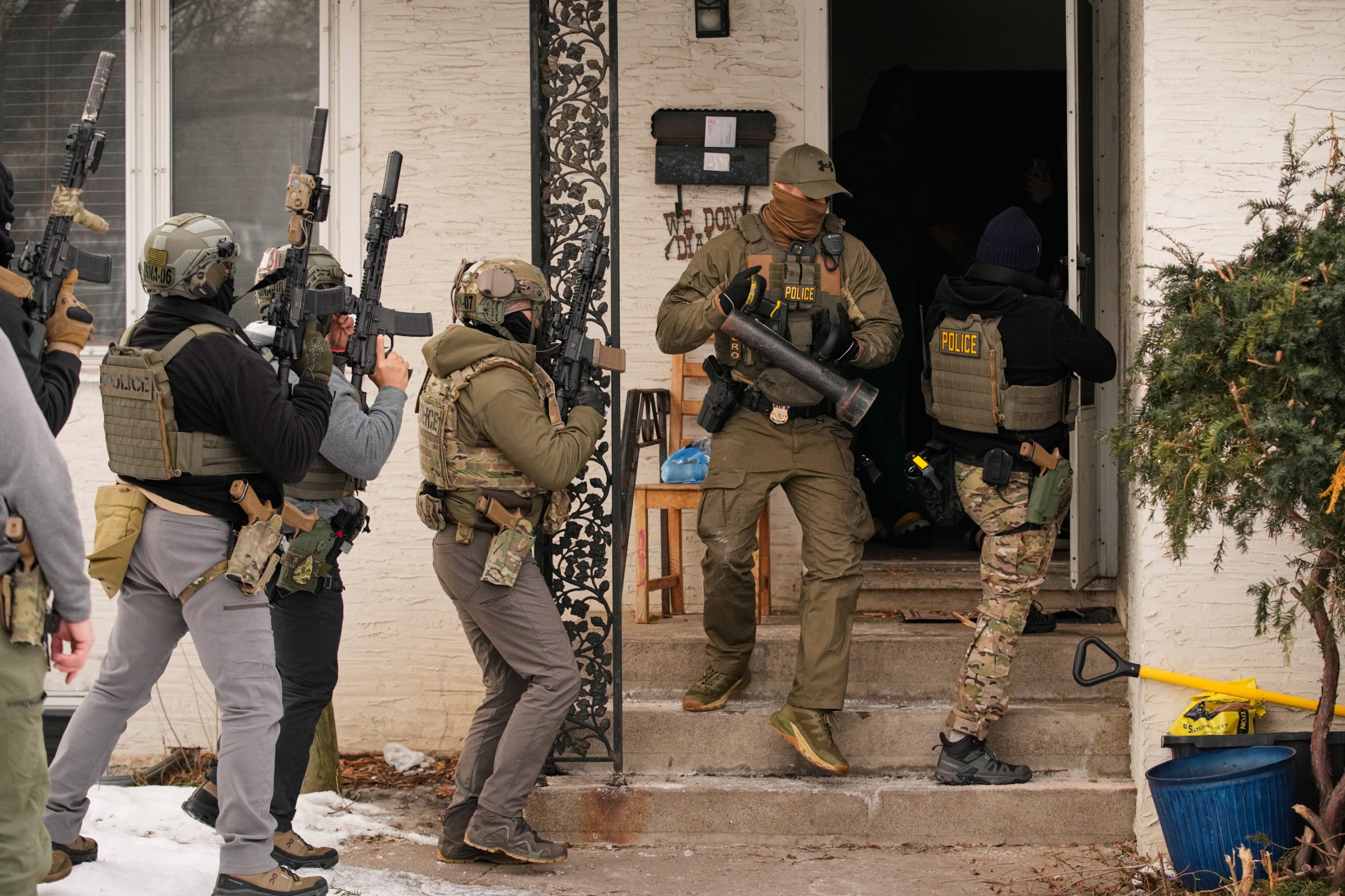 Federal immigration officers prepare to enter a home to make an arrest after an officer used a battering ram to break down a door Sunday, Jan. 11, 2026, in Minneapolis.