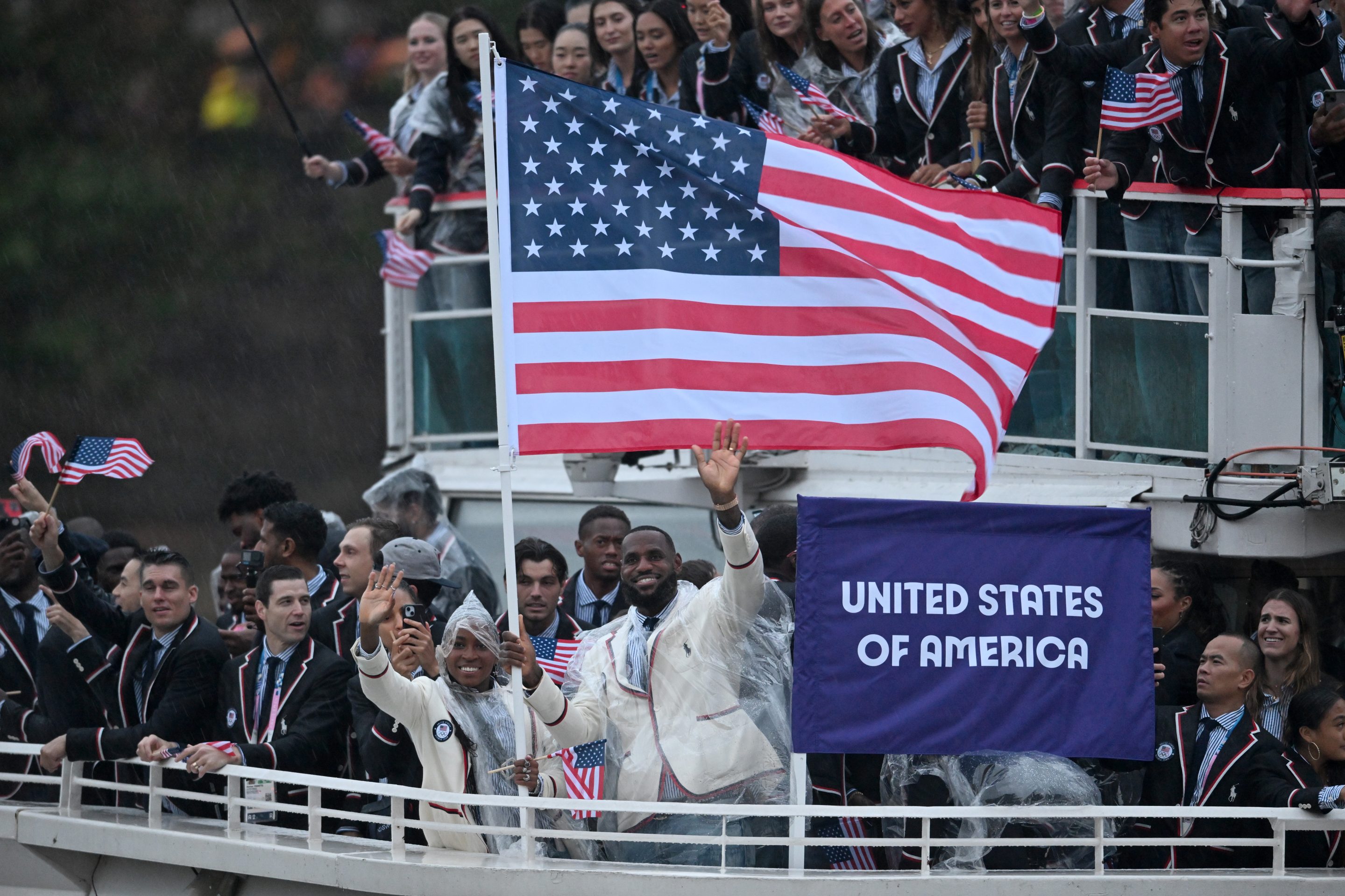 Lebron James holds the U.S. flag and waves on a boat.