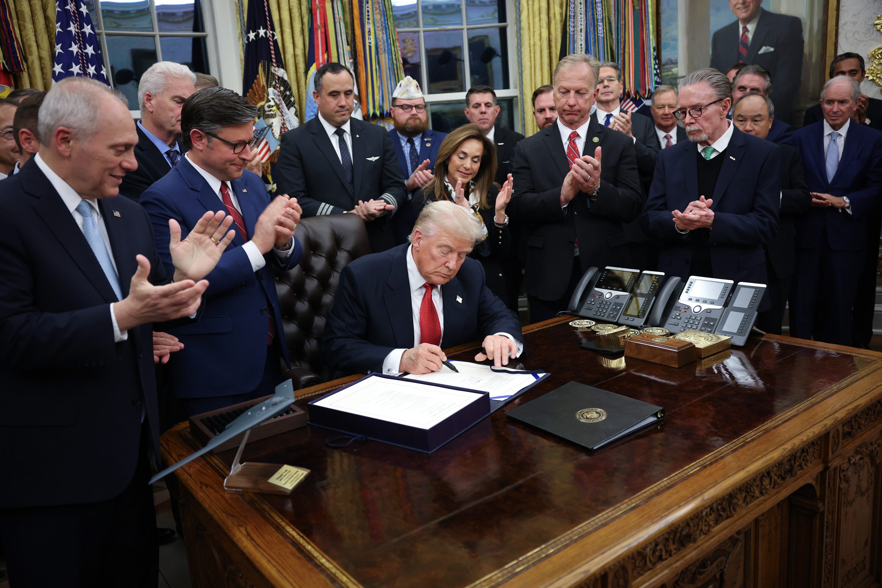 U.S. President Donald Trump signs funding legislation to reopen the federal government as he is joined by House Minority Leader Steve Scalise (R-LA), House Speaker Mike Johnson (R-LA), Republican lawmakers and business leaders, during a ceremony in the Oval Office of the White House on November 12, 2025, in Washington, DC.