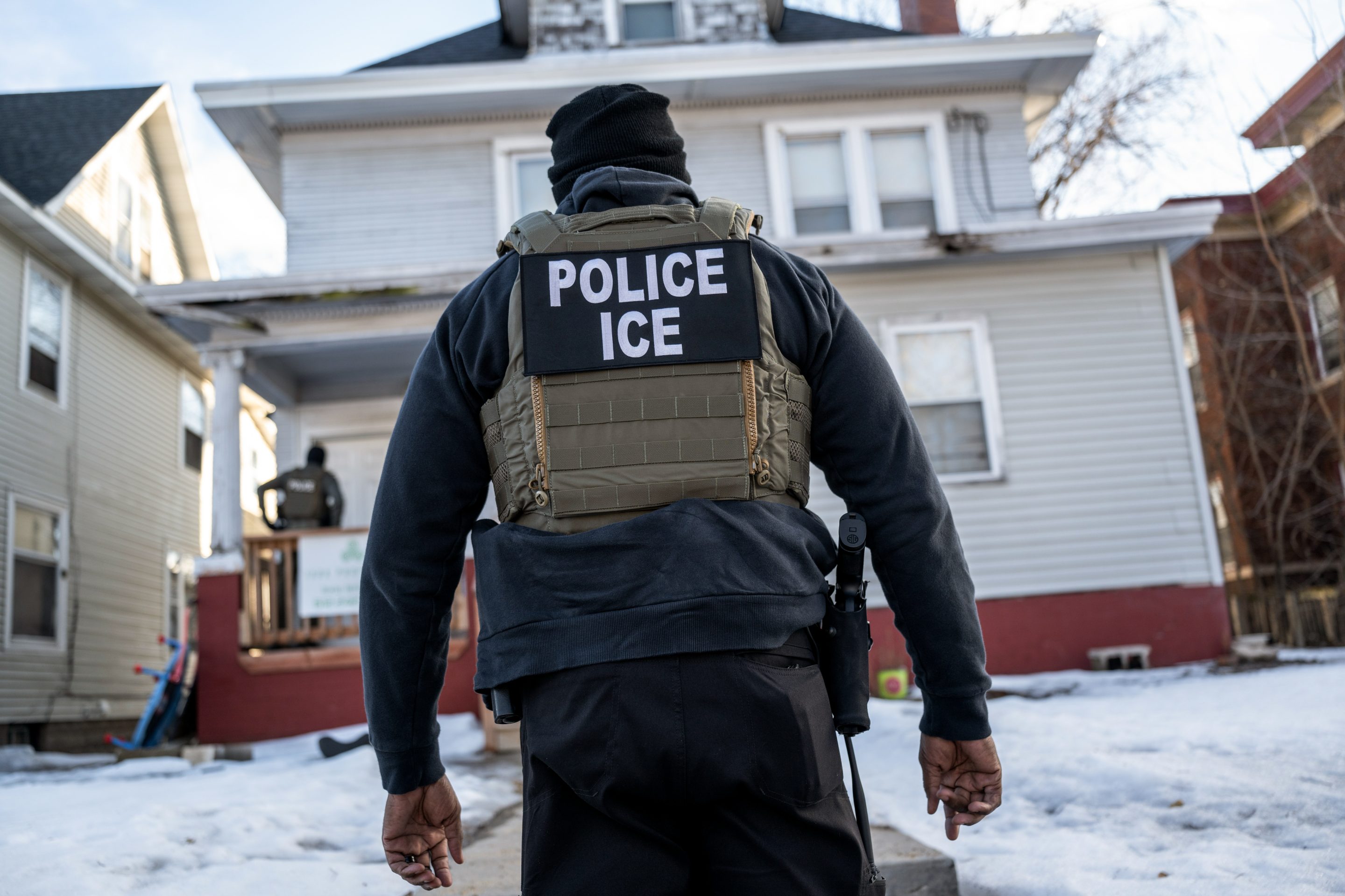 A federal law enforcement agent outside a home during a raid in south Minneapolis, Minnesota, US, on Tuesday, Jan. 13, 2026.