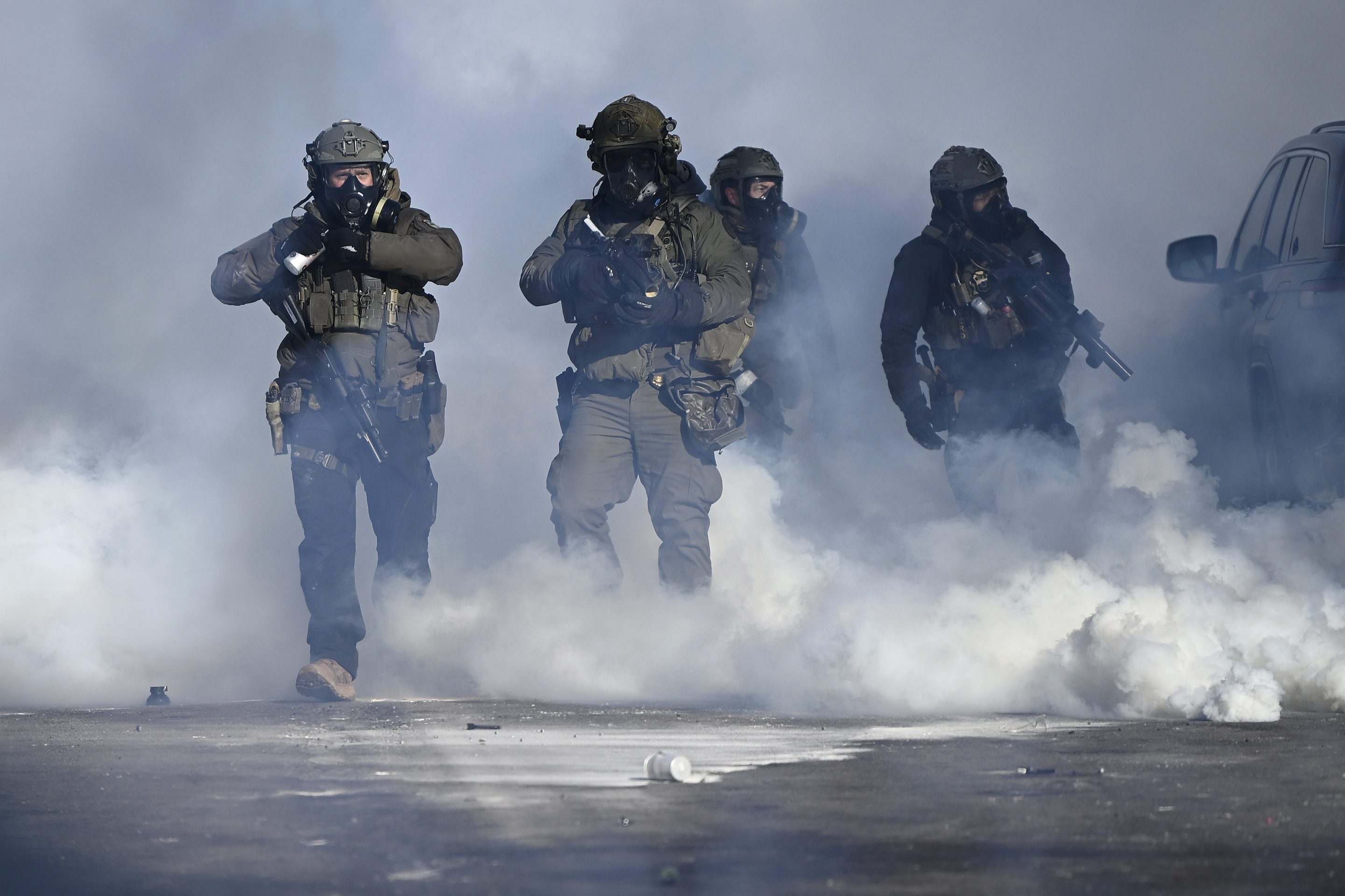 Federal agents point weapons amid tear gas fired at protesters on Jan. 24, 2026, in Minneapolis.