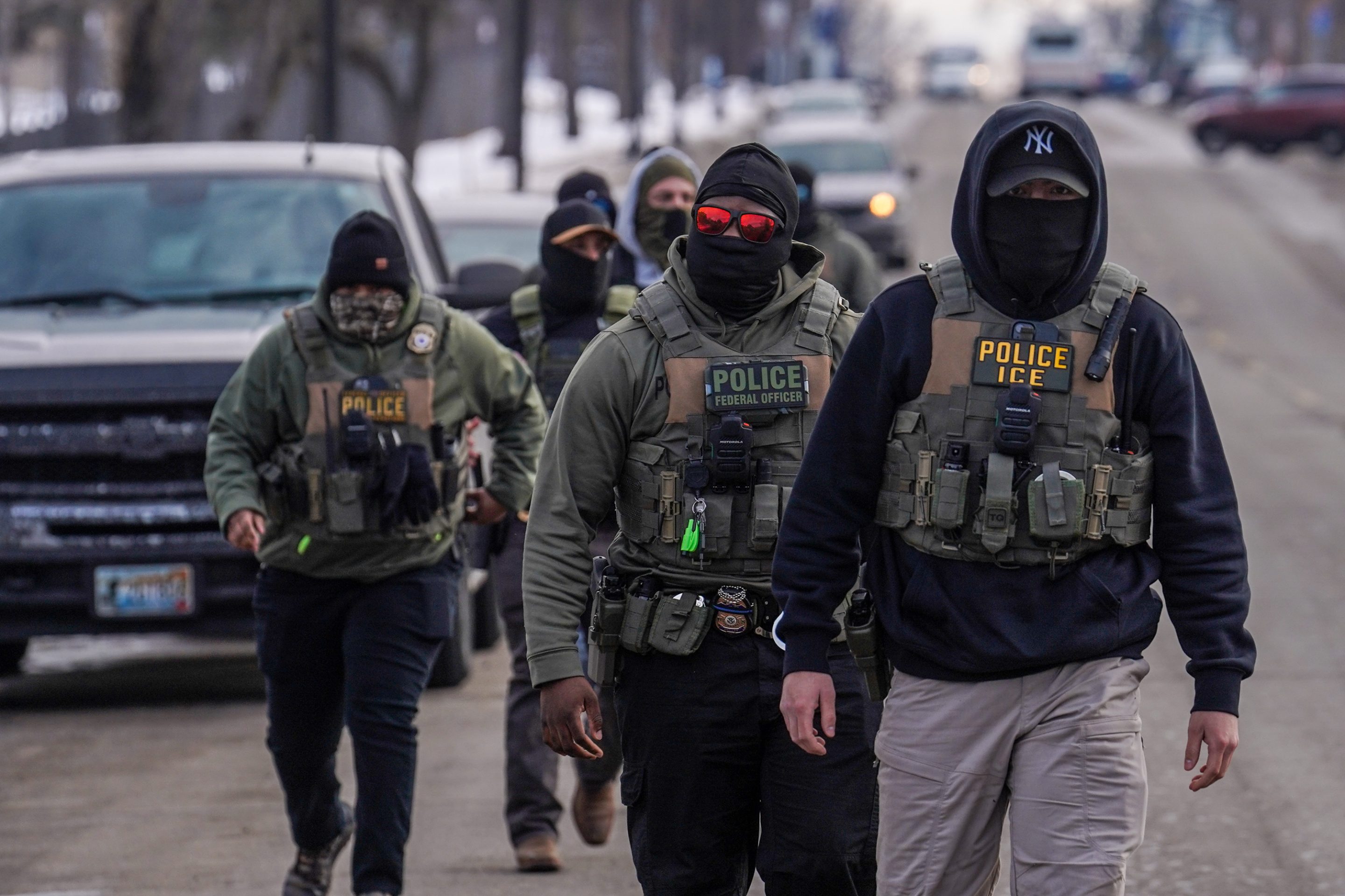 Federal agents walk down a street while conducting immigration enforcement operations, Thursday, Feb. 5, 2026, in Minneapolis.