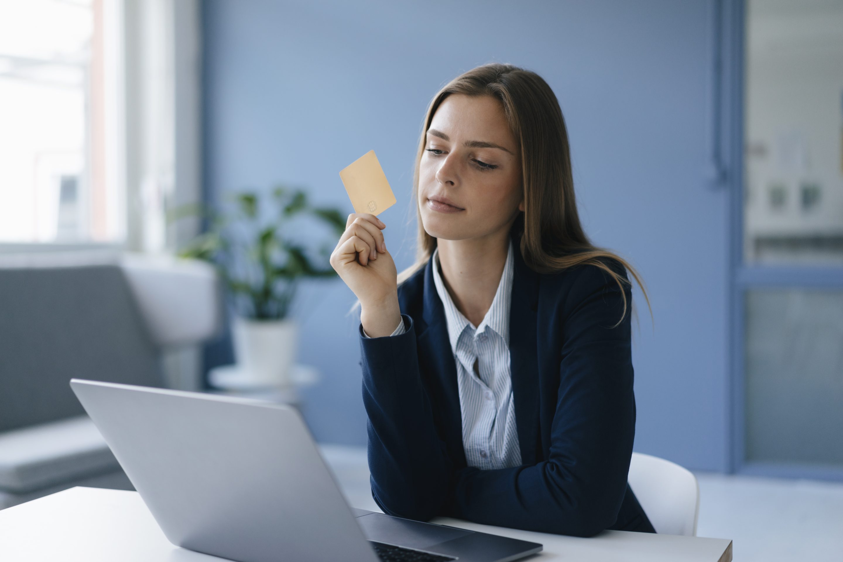 Young woman dressed in a suit completing an online payment with her credit card