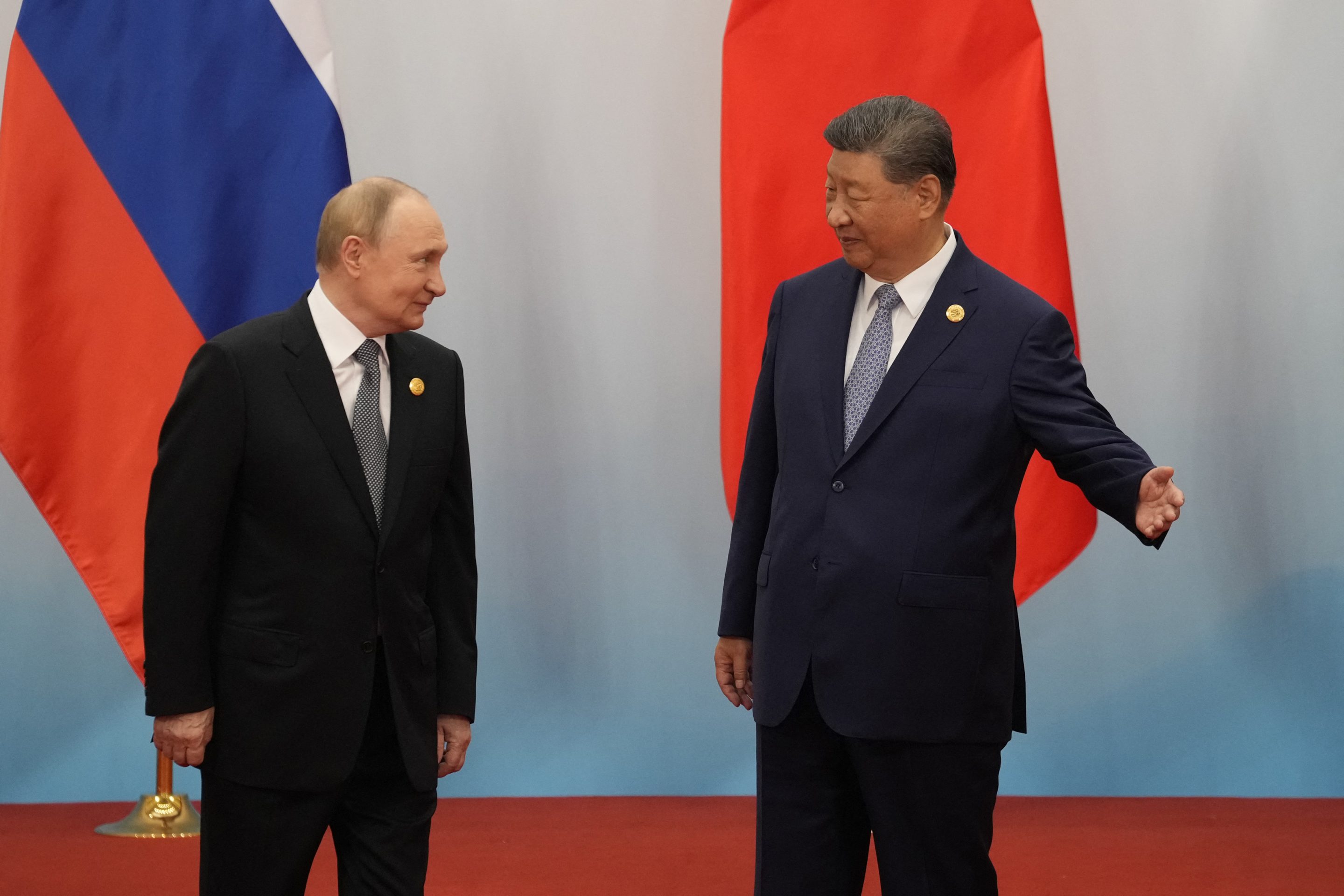 Chinese President Xi Jinping (R) shows the way to Russian President Vladimir Putin after the photo session of the Shanghai Cooperation Organization (SCO) Summit 2025 at the Meijiang Convention and Exhibition Centre in Tianjin on September 1, 2025.