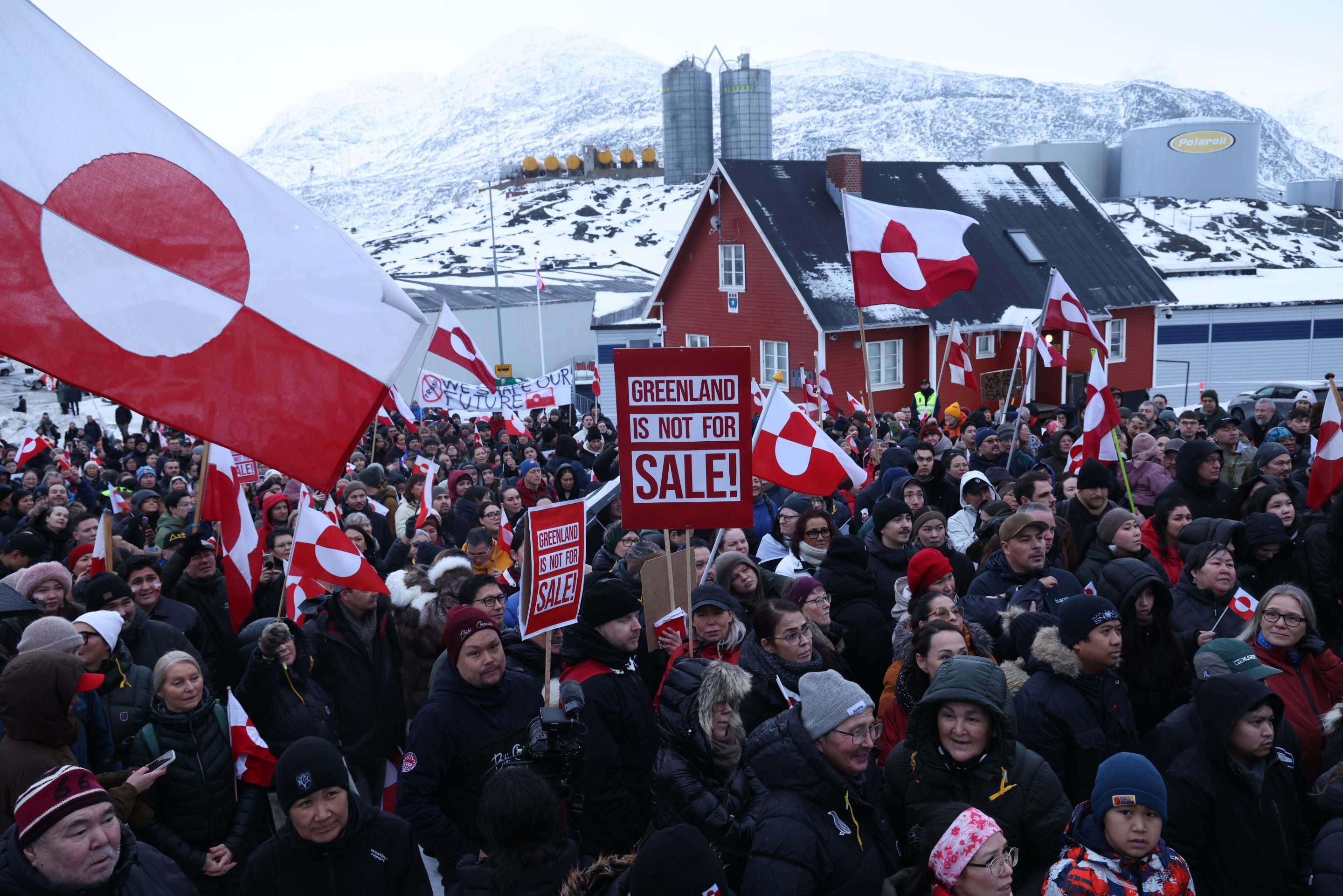 People hold Greenlandic flags and placards as they gather by the United States Consulate to march in protest against U.S. President Donald Trump and his announced intent to acquire Greenland on January 17, 2026 in Nuuk, Greenland.