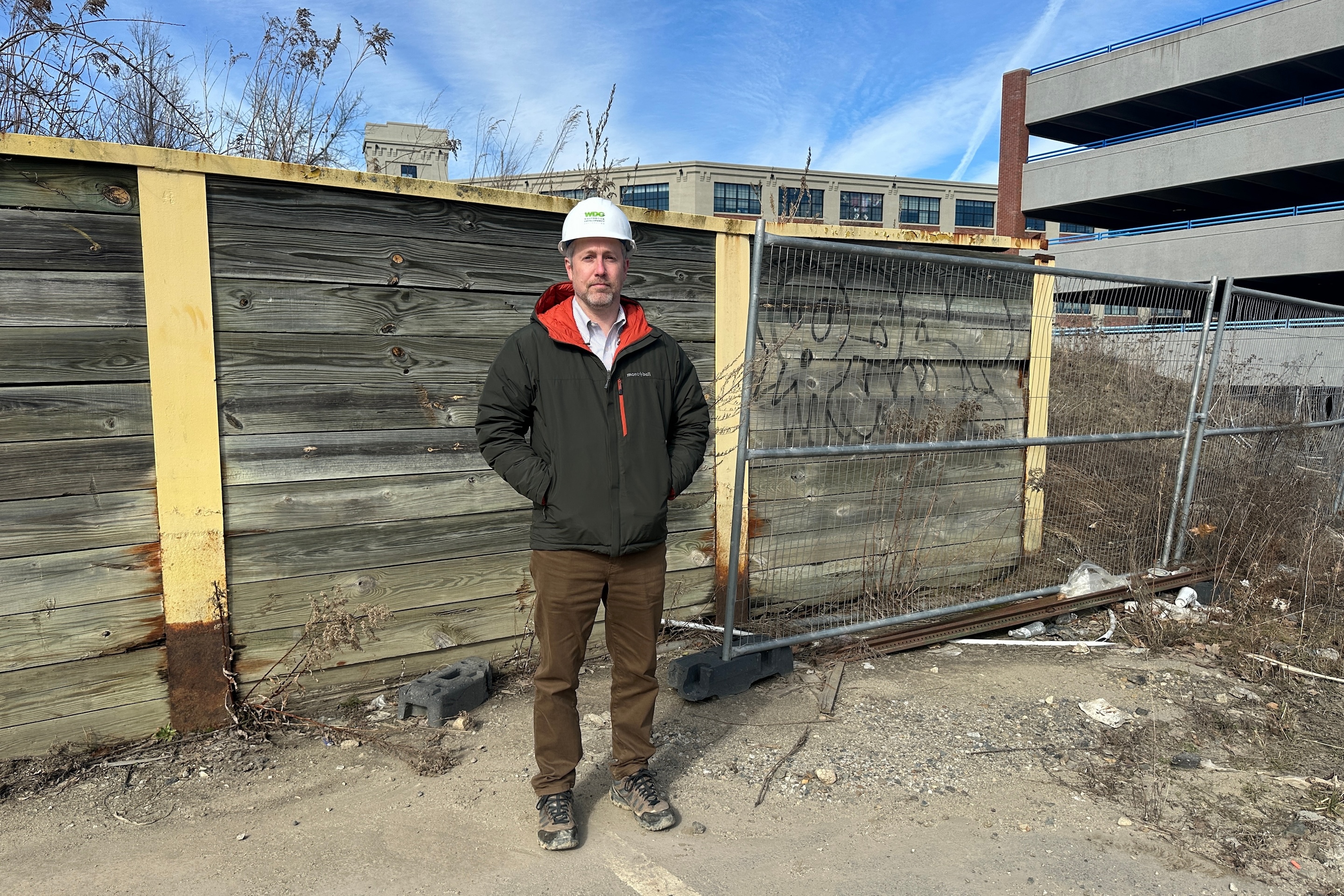Tyler Norod, from the Westbrook Development Corporation, stands for a photo at a development site.