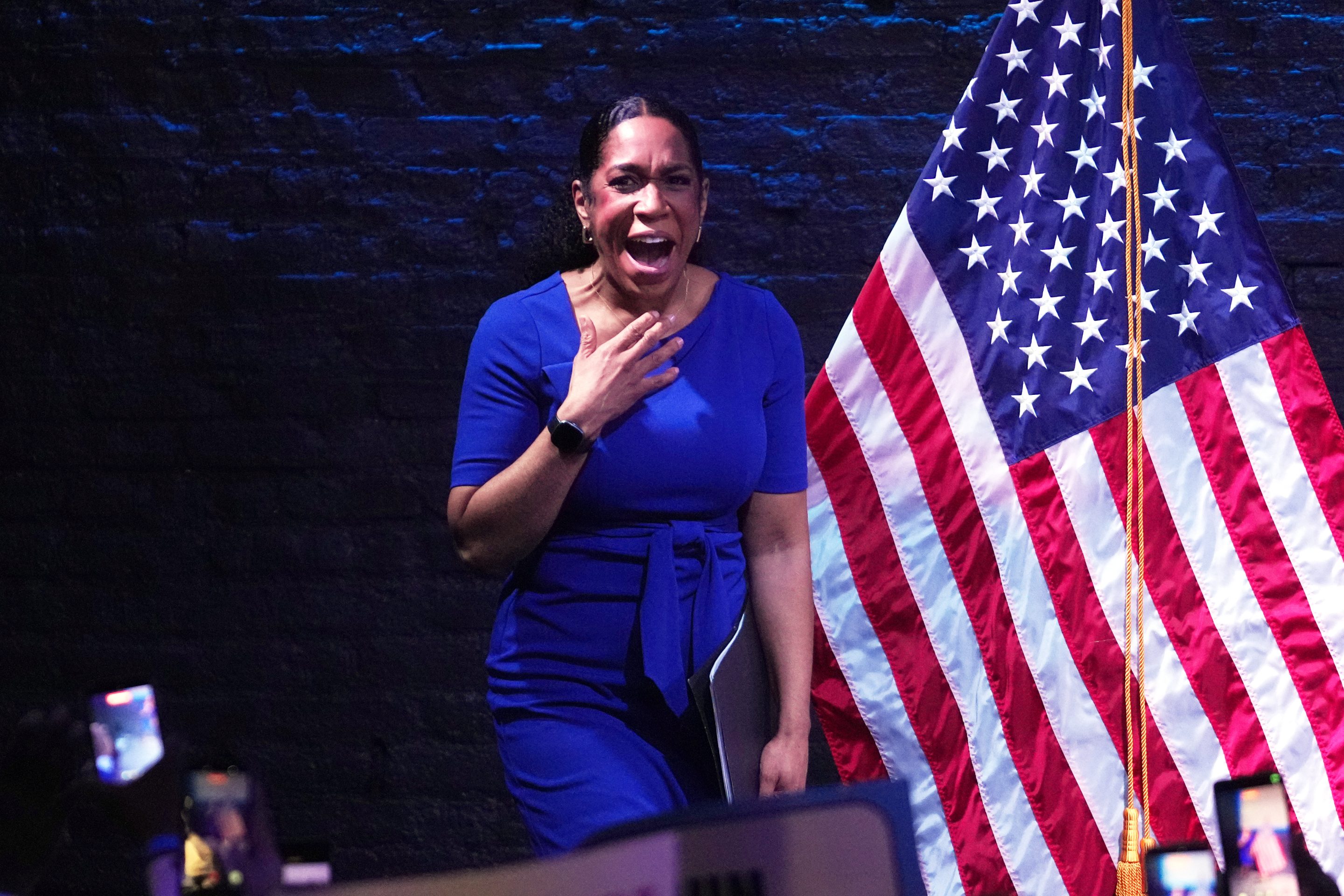 Woman in blue in front of the American flag