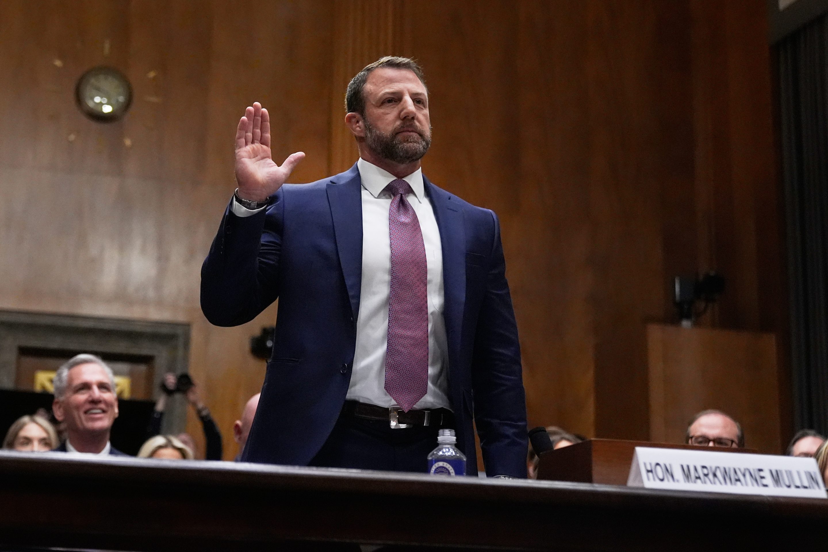 man in suit raising hand swearing oath