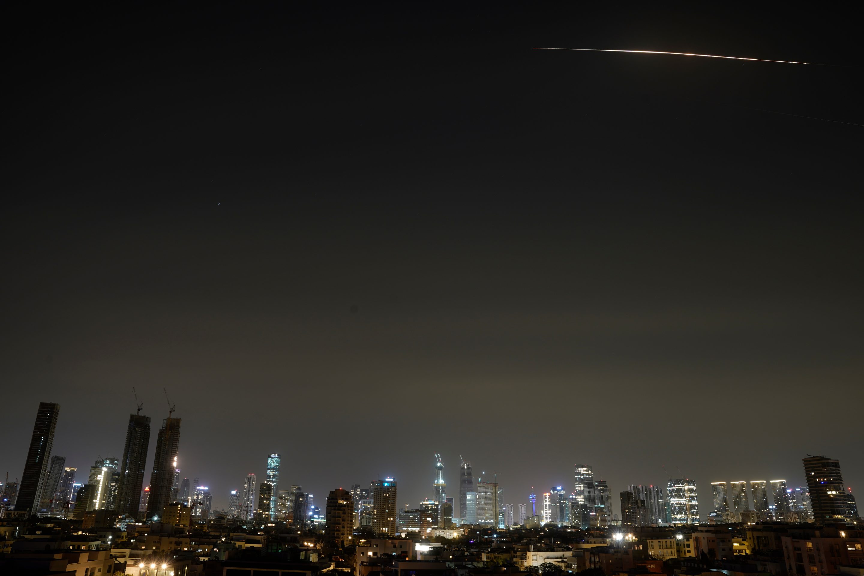 The remains of an Iranian missile cross the sky over Tel Aviv after being intercepted early Saturday, March 21, 2026.