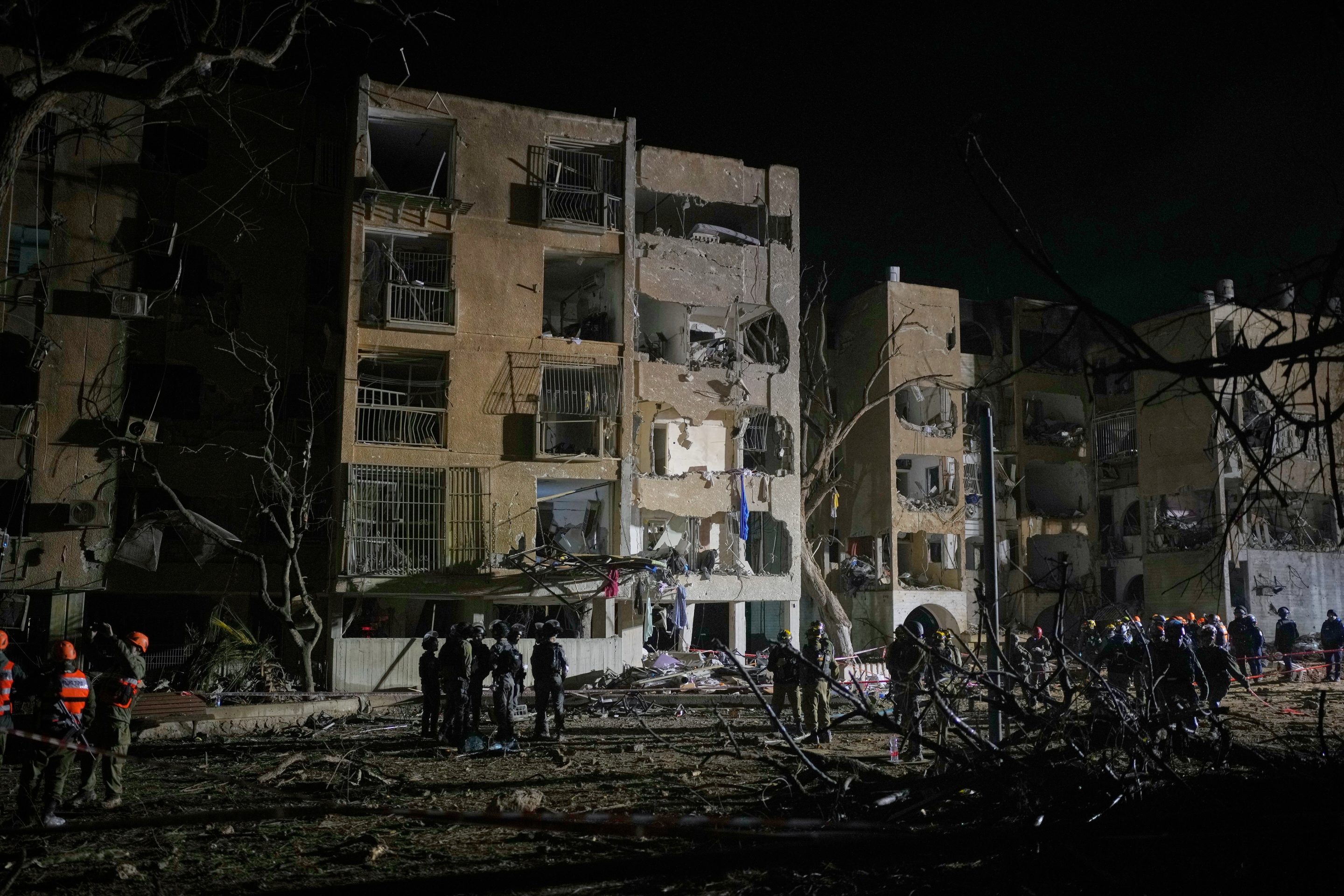 Israeli security forces and rescue teams work at the site struck by an Iranian missile in Arad, southern Israel, Sunday, March 22, 2026. 