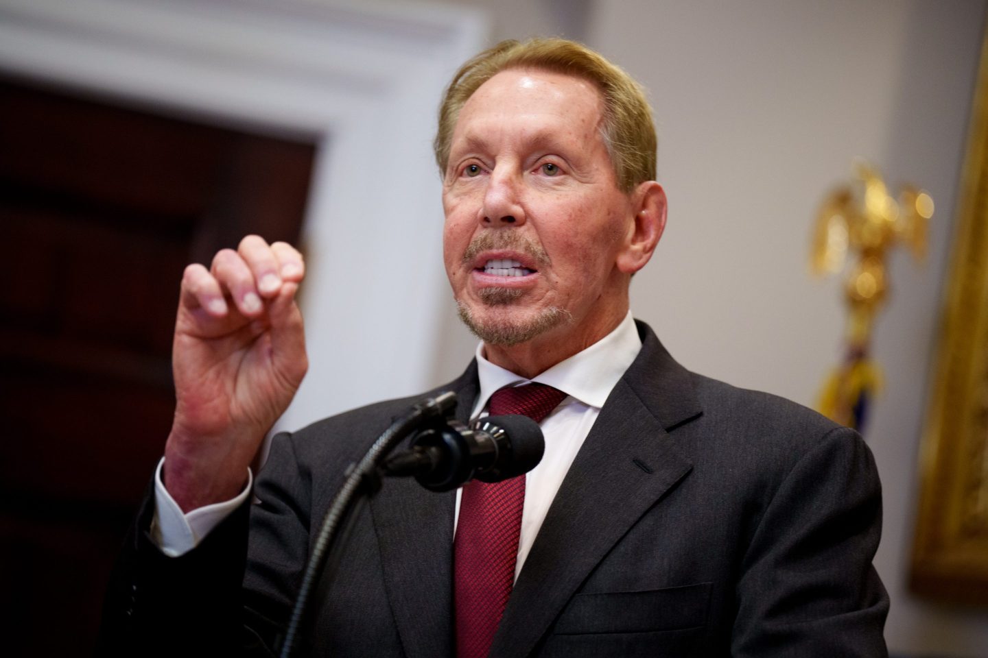 Man in a suit and tie gesturing while talking.