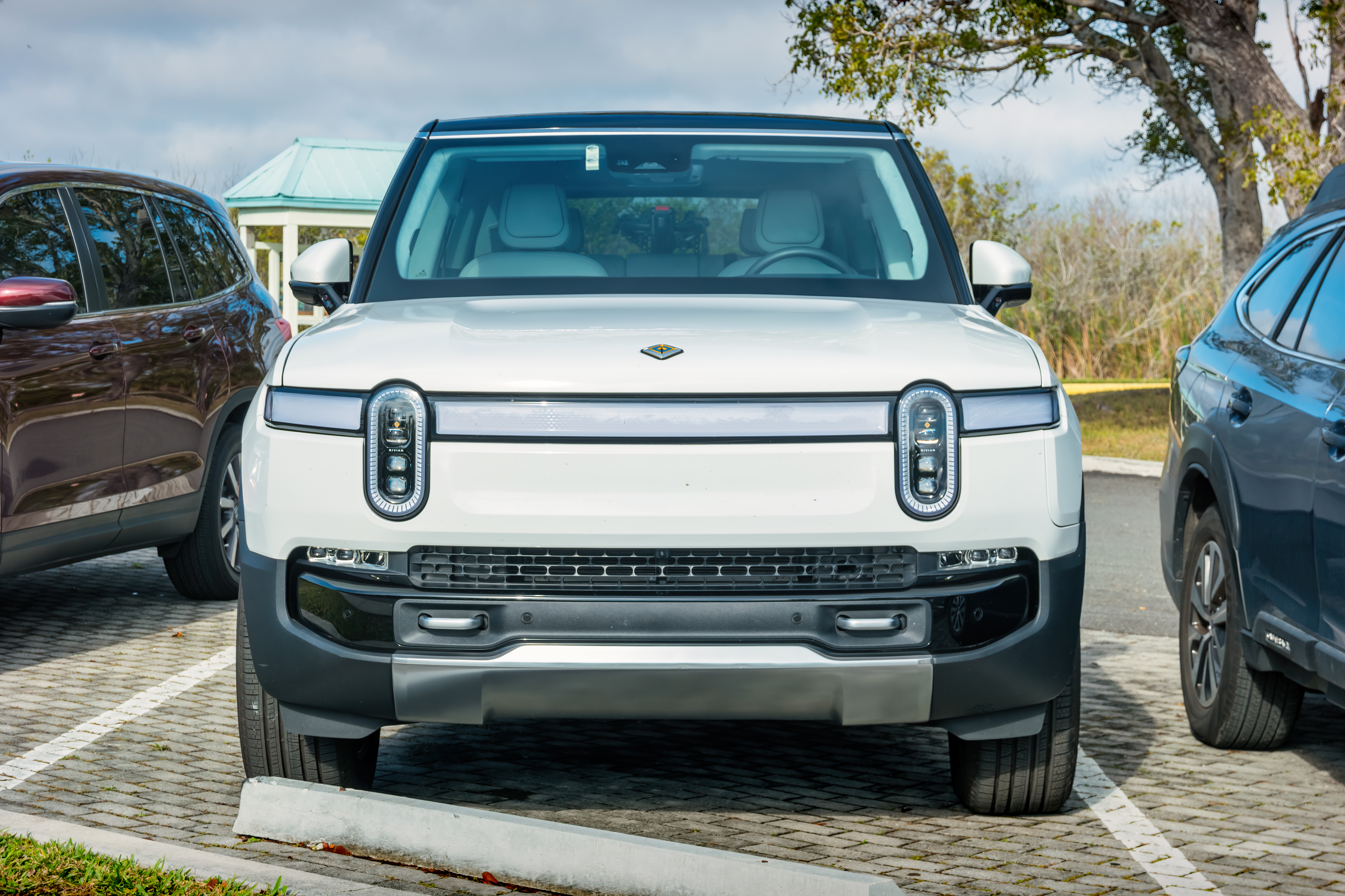 A white colored Rivian R1S electric SUV.