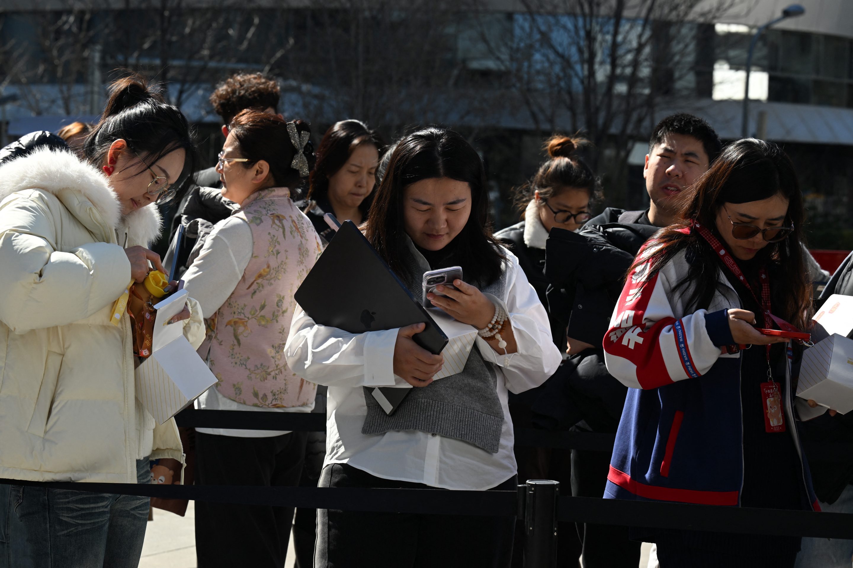 People queue to have their laptops install with OpenClaw, an open-source AI assistant at the Baidu headquarters in Beijing on March 11, 2026.