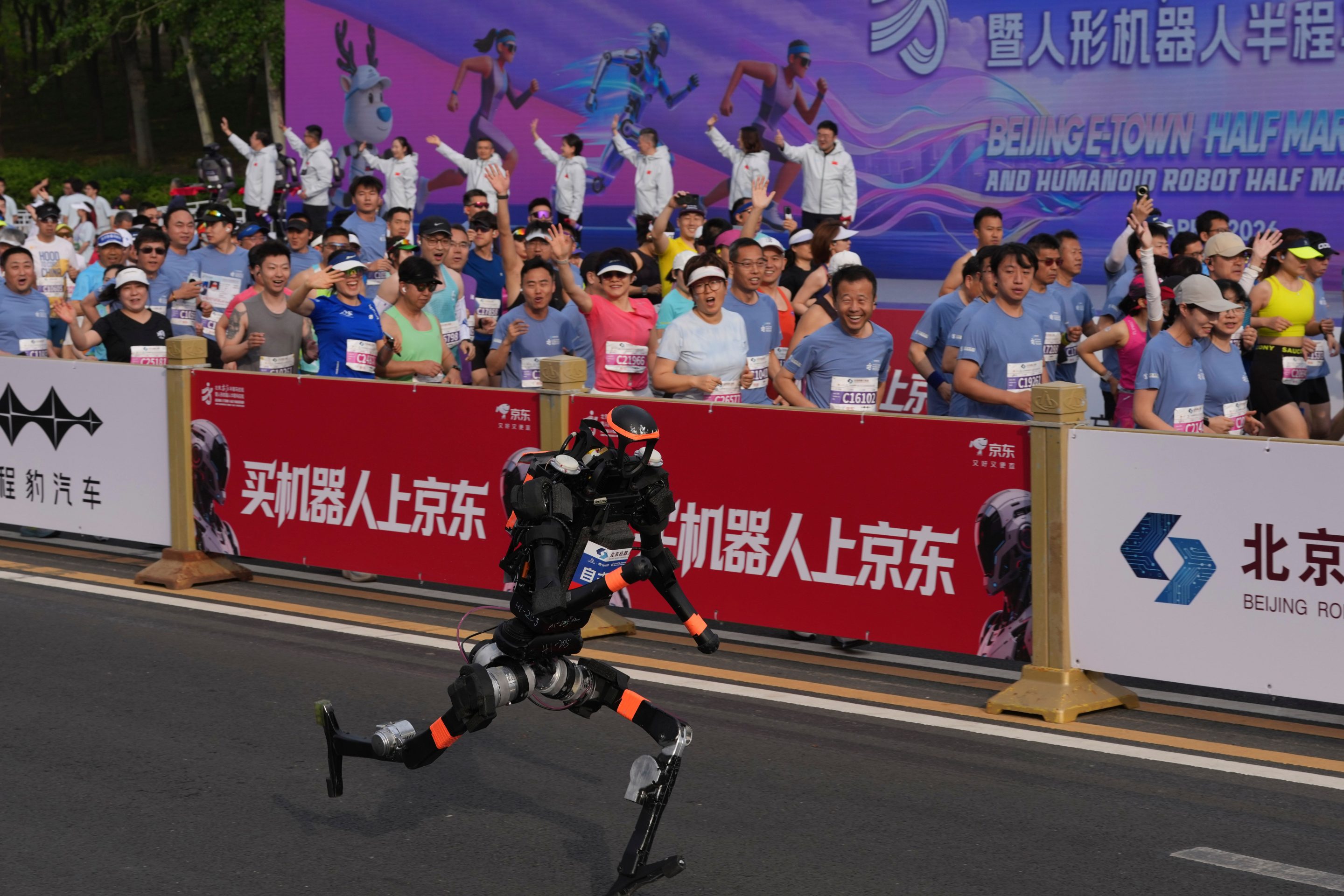 A robot starts off next to human marathon runners for the Beijing E-Town Half Marathon and Humanoid Half Marathon held on the outskirts of Beijing on Sunday April 19, 2026.
