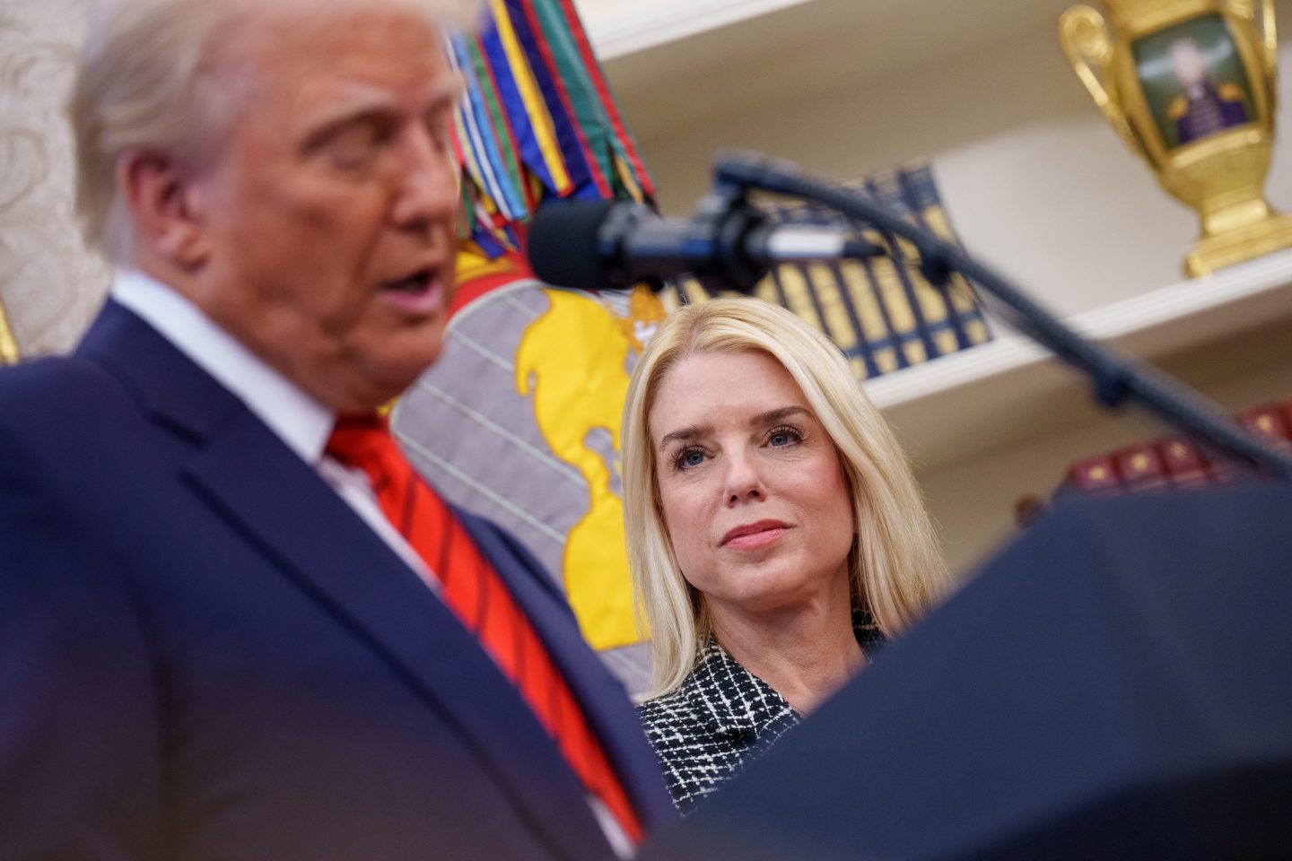 Trump at podium with bondi watching