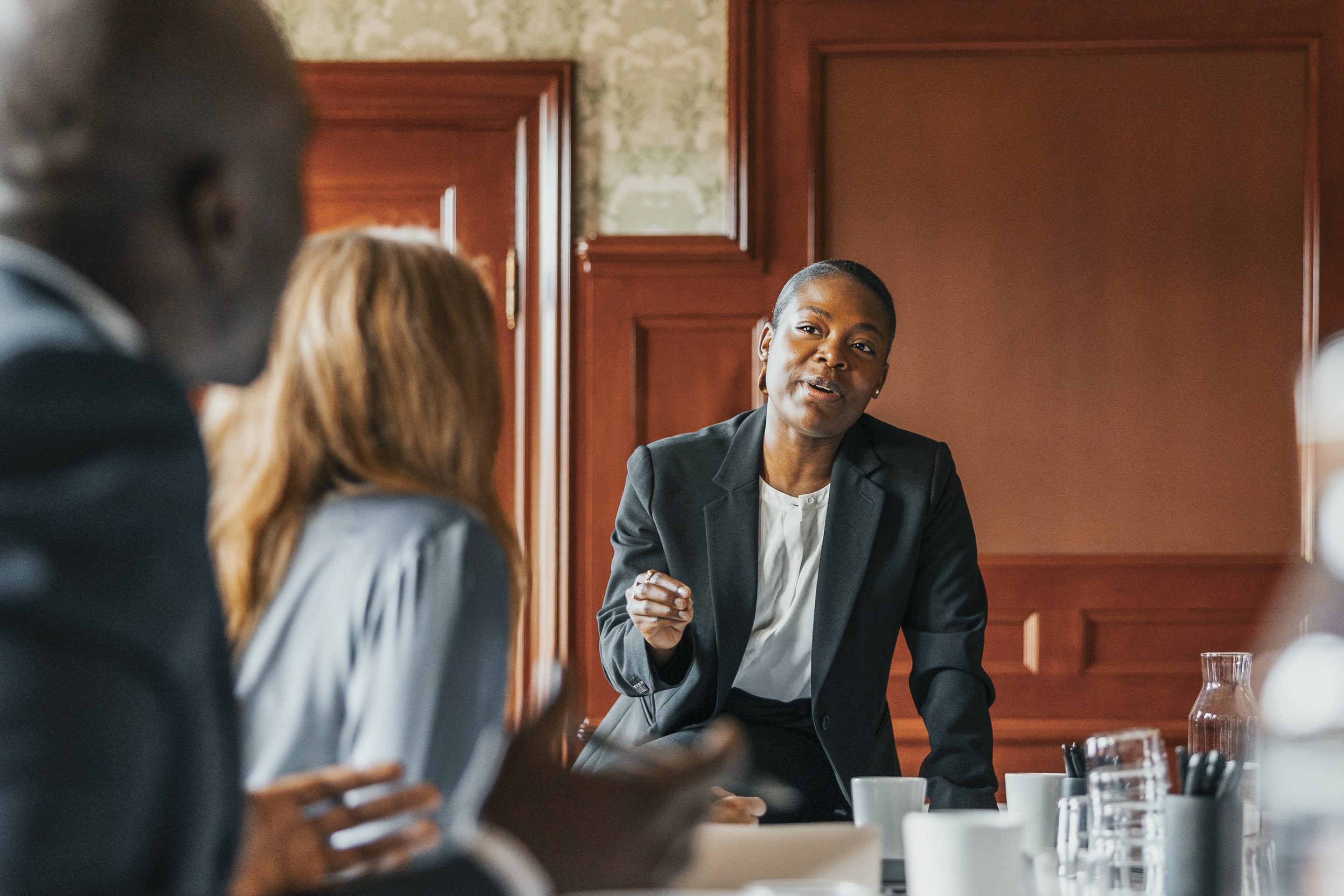 Female boss talking to colleagues in meeting room