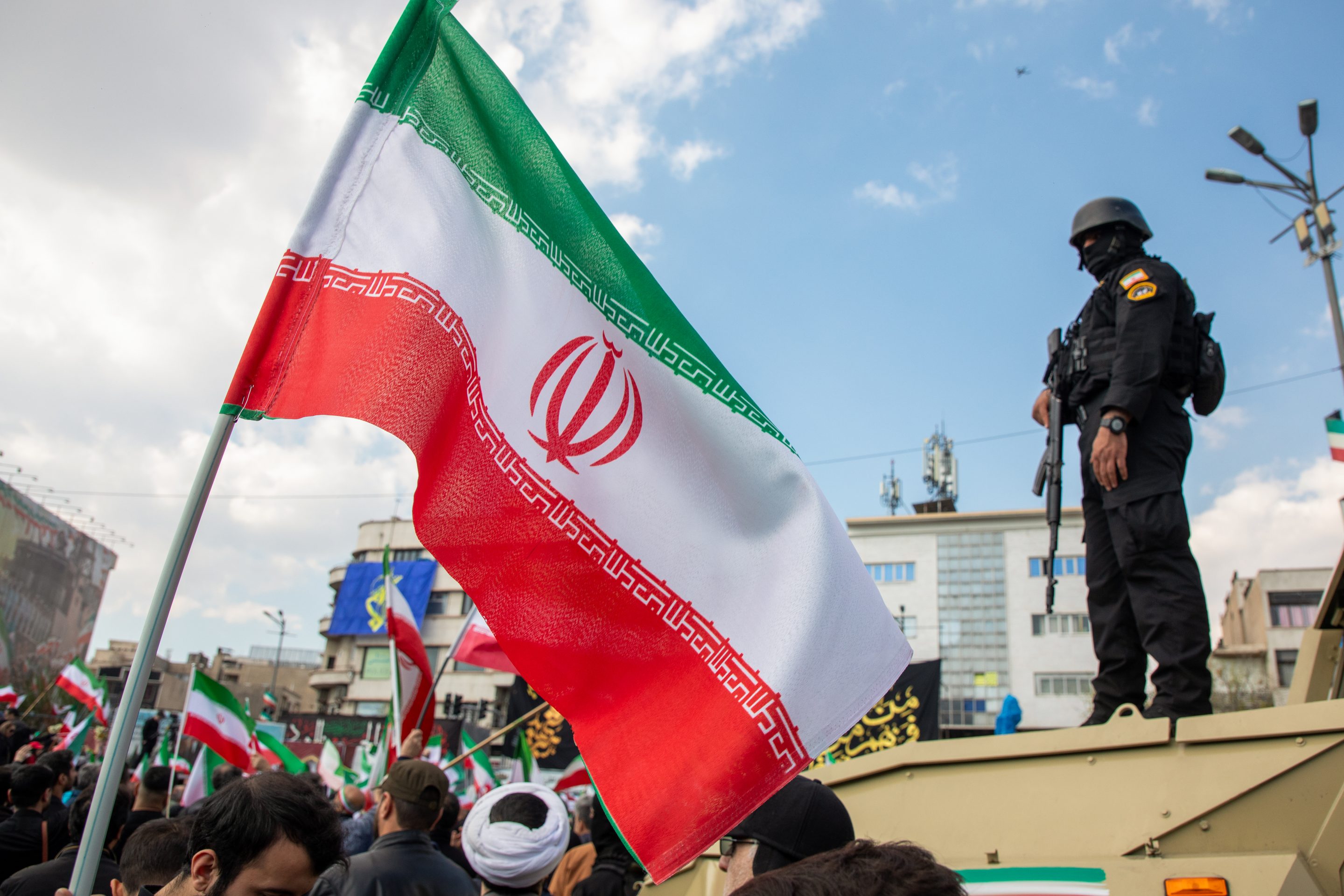 Members of security forces watch over the crowd during a funeral procession held for IRGC Navy Chief Alireza Tangsiri, alongside other senior naval commanders and their families who were killed in US-Israeli strikes in late March, on April 1, 2026 in Tehran, Iran.