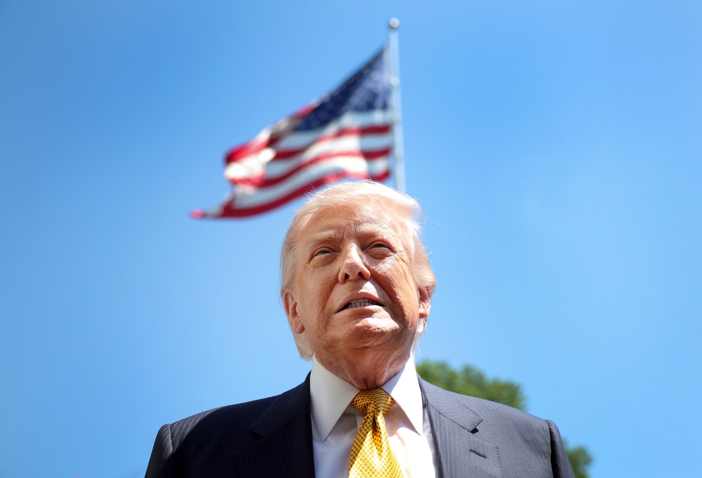 President Donald Trump speaks in front of the American flag to the press as he departs the White House on May 12, 2026 in Washington, DC.