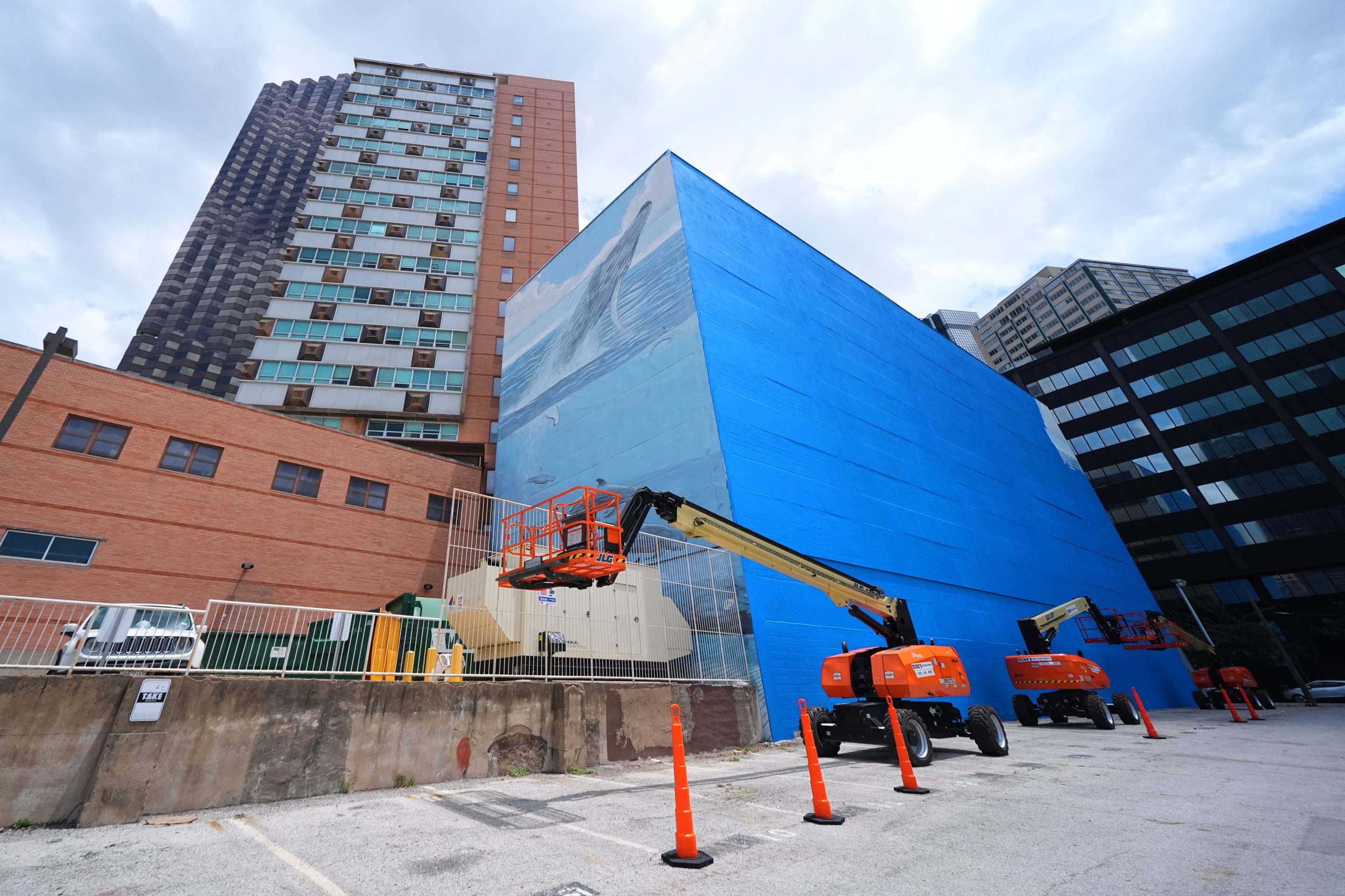 A section of a mural, known as the "Whaling Wall 82," created by artist Wyland, is visible as part of it on the right side of the building was painted over, Monday, May 18, 2026, in Dallas.