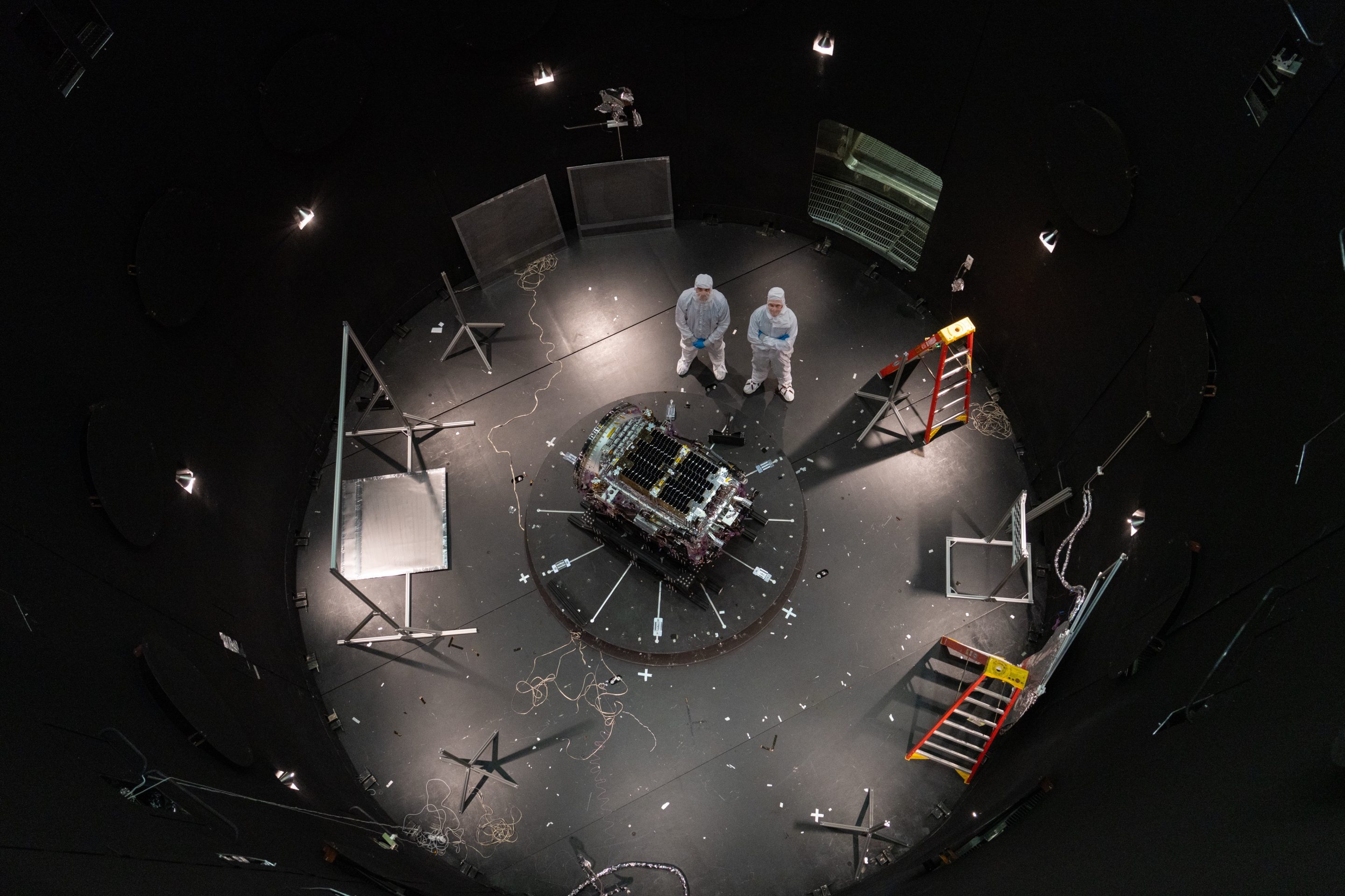 This photo provided by NASA shows Kieran Wilson, LINK’s principal investigator, and Hunter Robertson, a space systems engineer, both at Katalyst Space, standing next to their spacecraft inside the SES (Space Environment Simulator) at NASA’s Goddard Space Flight Center in Greenbelt, Md., April 17, 2026, ahead of thermal vacuum testing.