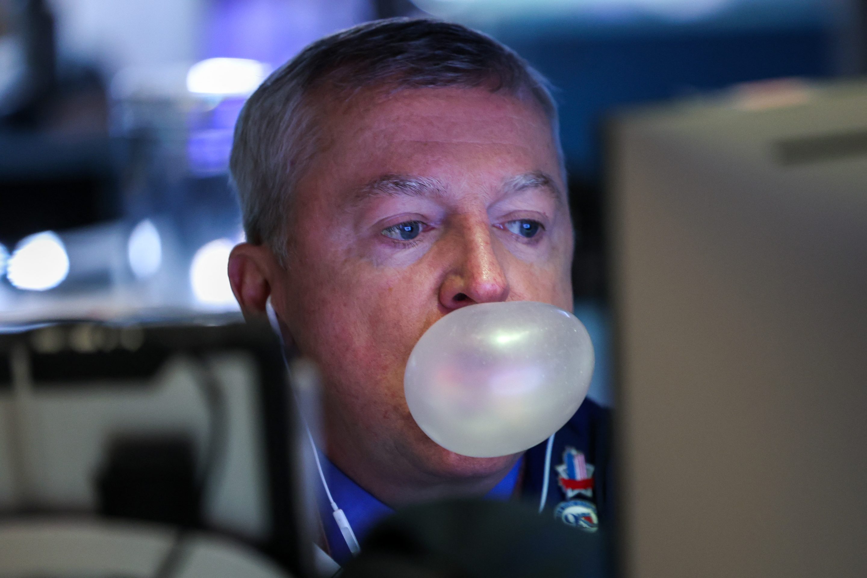 A trader blows a chewing gum bubble as he works on the floor of the New York Stock Exchange (NYSE) following the opening bell on March 5, 2026.