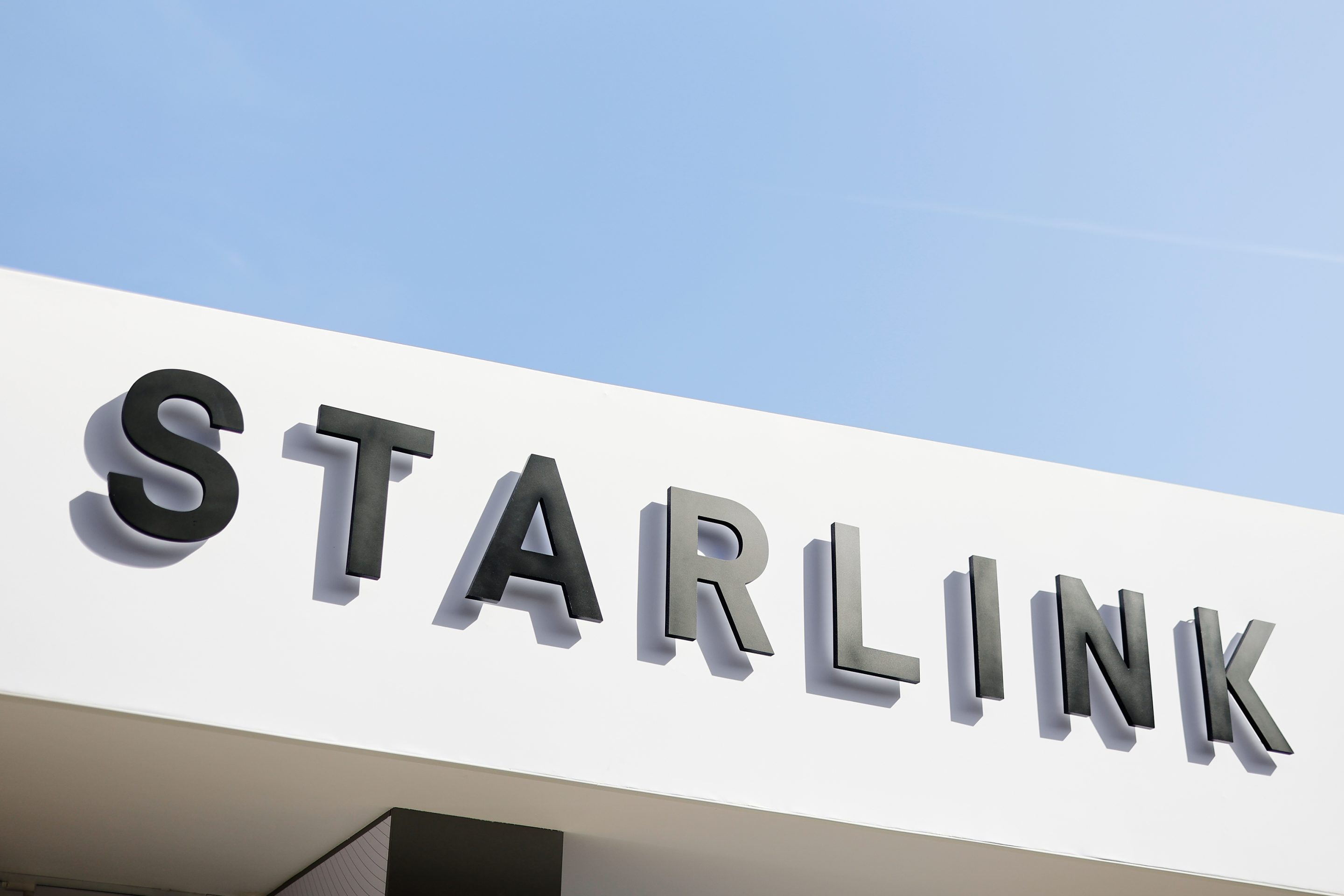 The Starlink corporate logo, part of the SpaceX ecosystem, is seen against a clear blue sky at the Fira Gran Via in Barcelona, Spain, on March 5, 2026.