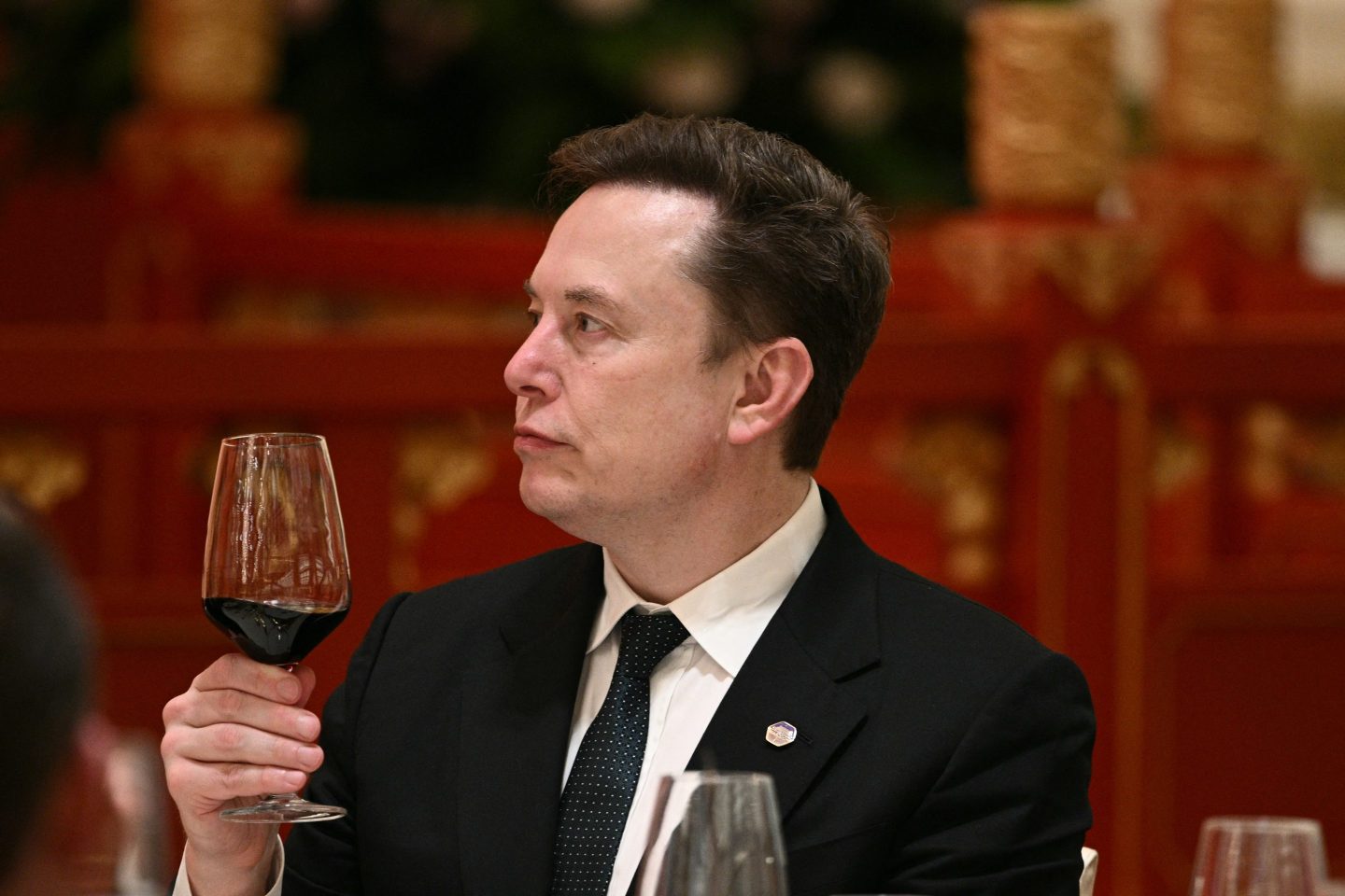 Elon Musk holding a glass of wine during a U.S. diplomatic visit to China