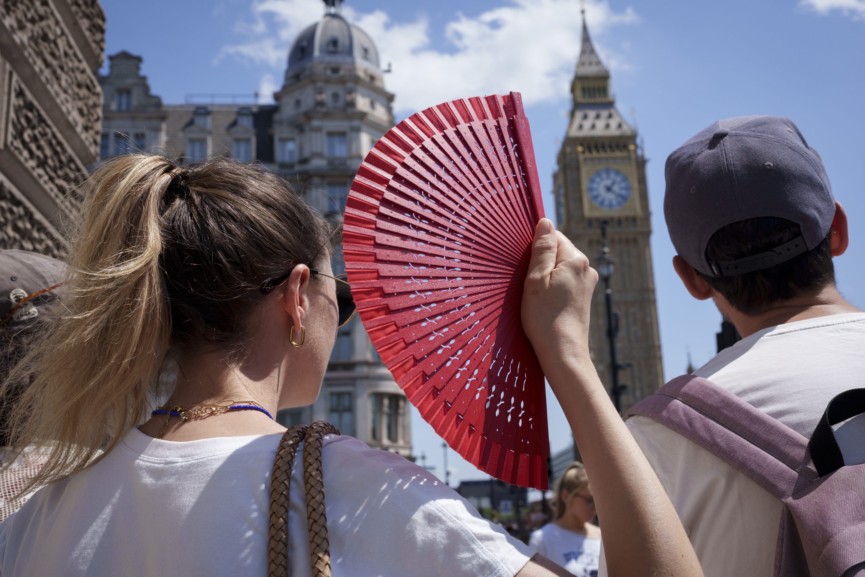 A visitor to the capital fans herself in front of Parliament during the latest heatwave, on June 19, 2026, in London.
