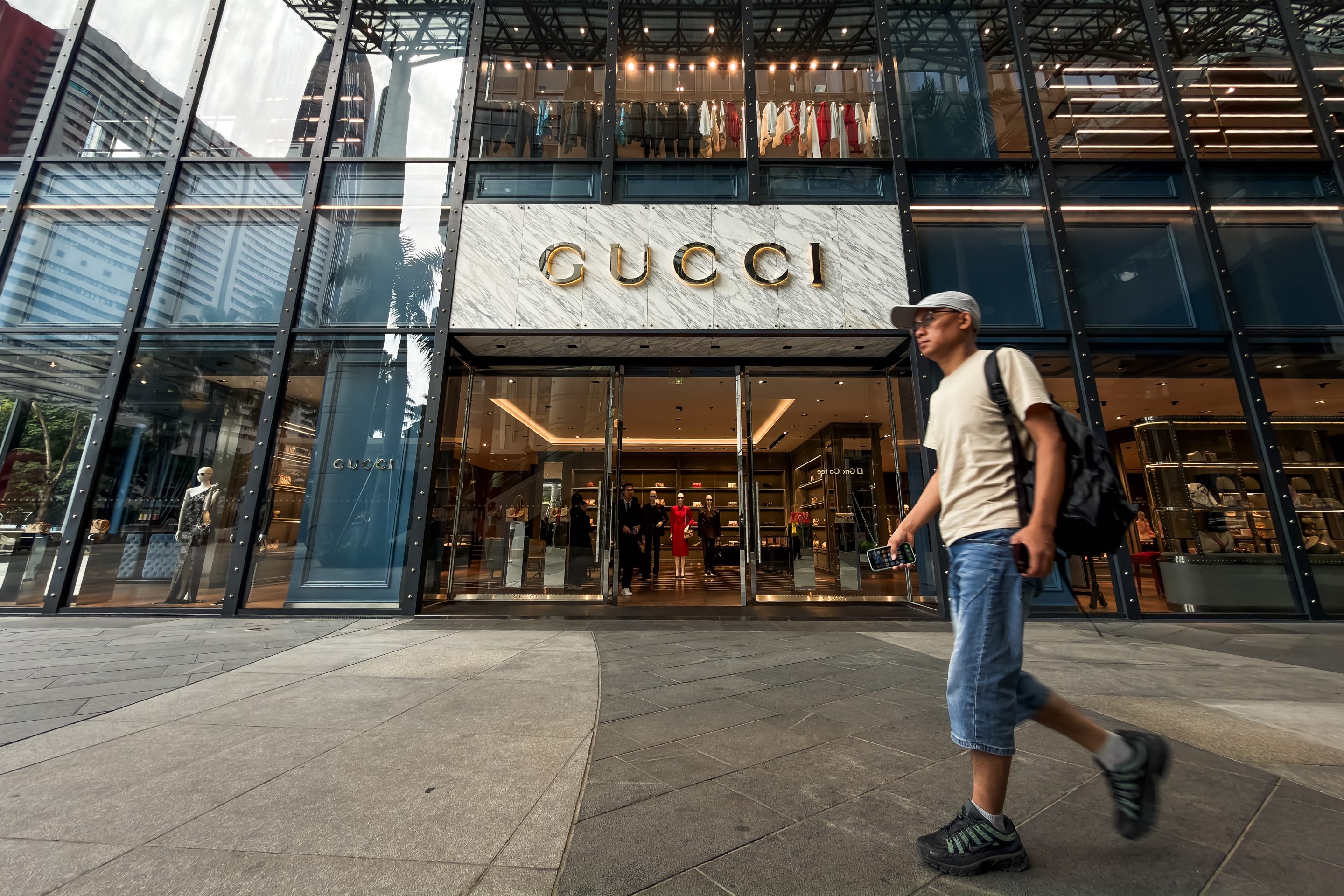 A pedestrian walks past a Gucci luxury fashion store at a shopping district on June 24, 2026, in Shenzhen, Guangdong Province, China.