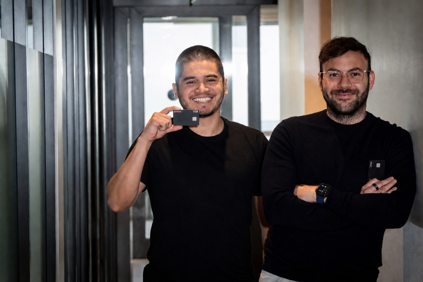 Karta founders Orlando Espinoza and Freddy Juez smile at the camera while holding up Karta cards.