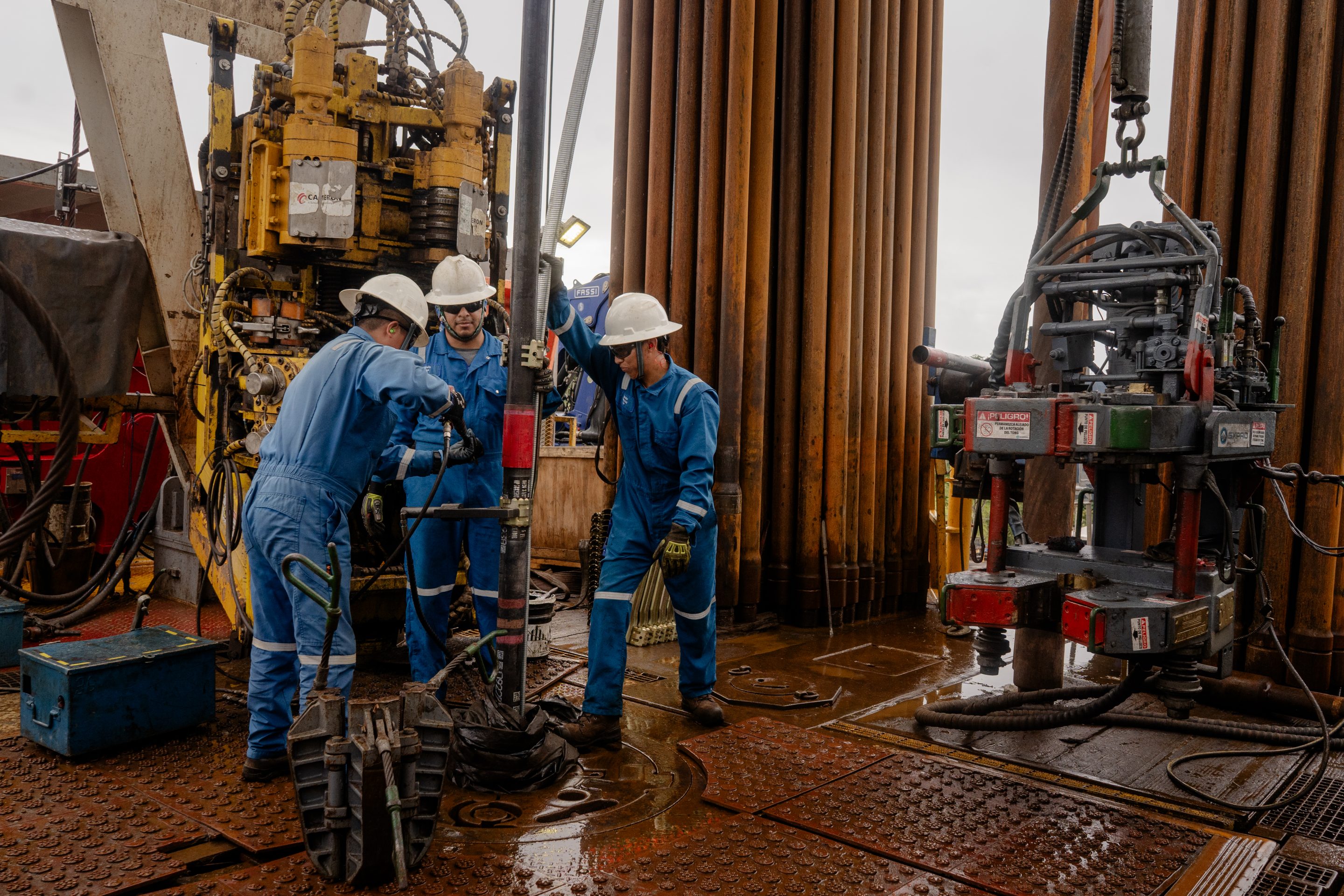 SLB workers lower a pump assembly into a well in Orellana, Ecuador.