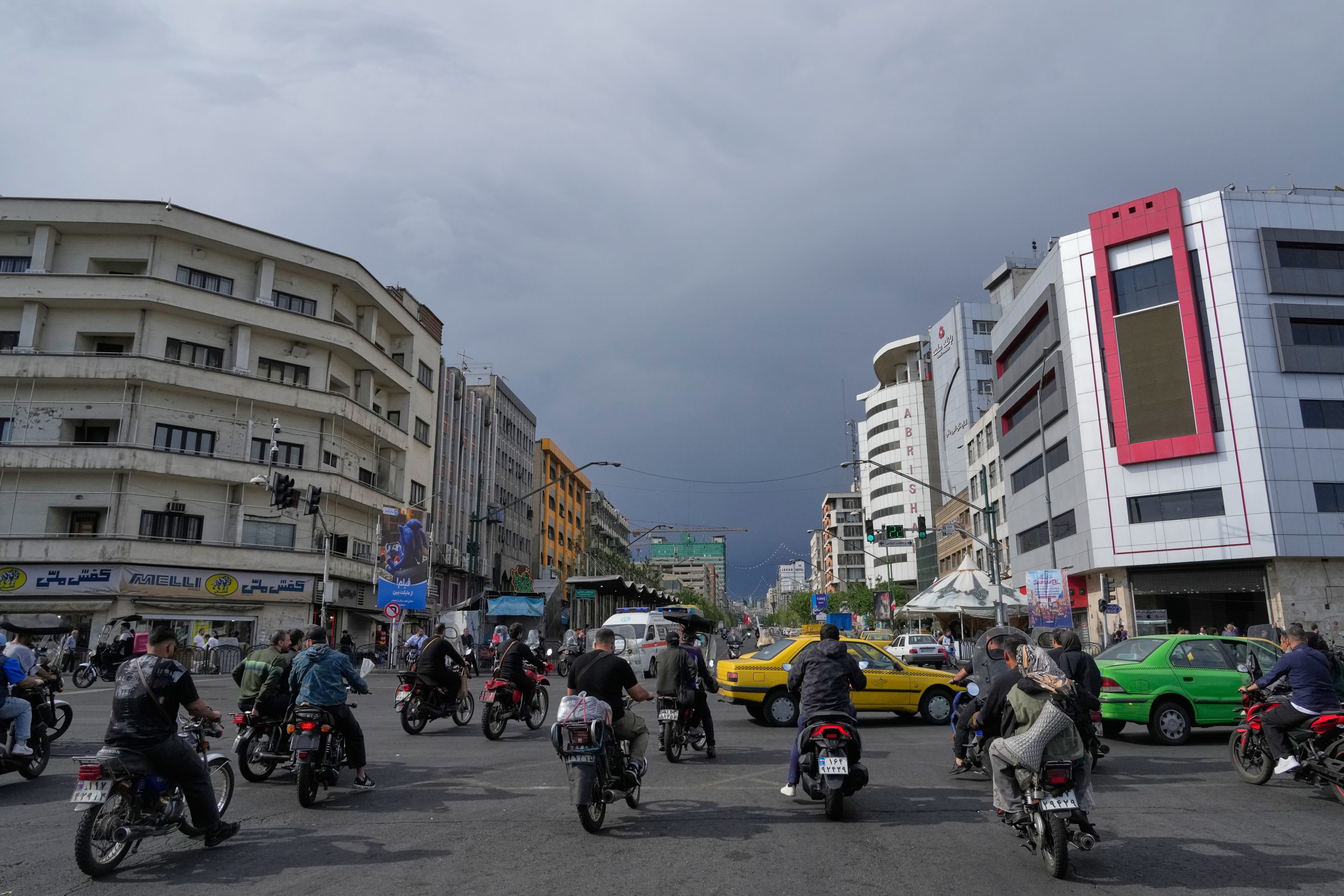 Motorbikes and cars pass through an intersection in downtown Tehran, Iran, May 17, 2026.