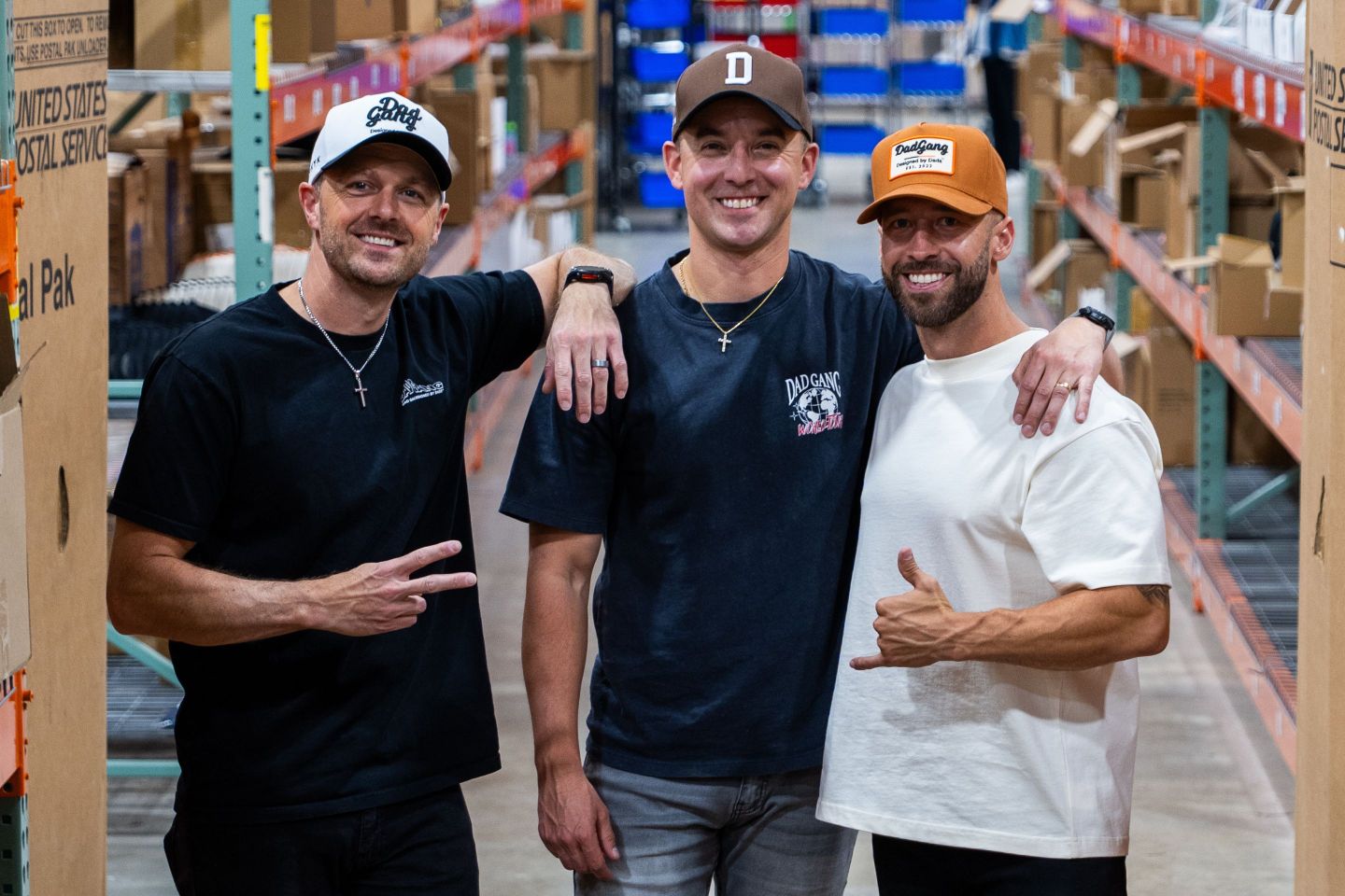 Ejay O'Donnell, Bart Szaniewski, and Grant Eastey wear Dad Gang hats in a factory