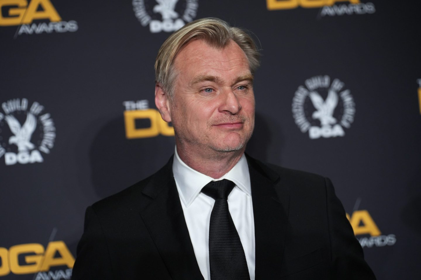 Christopher Nolan wearing a black suit