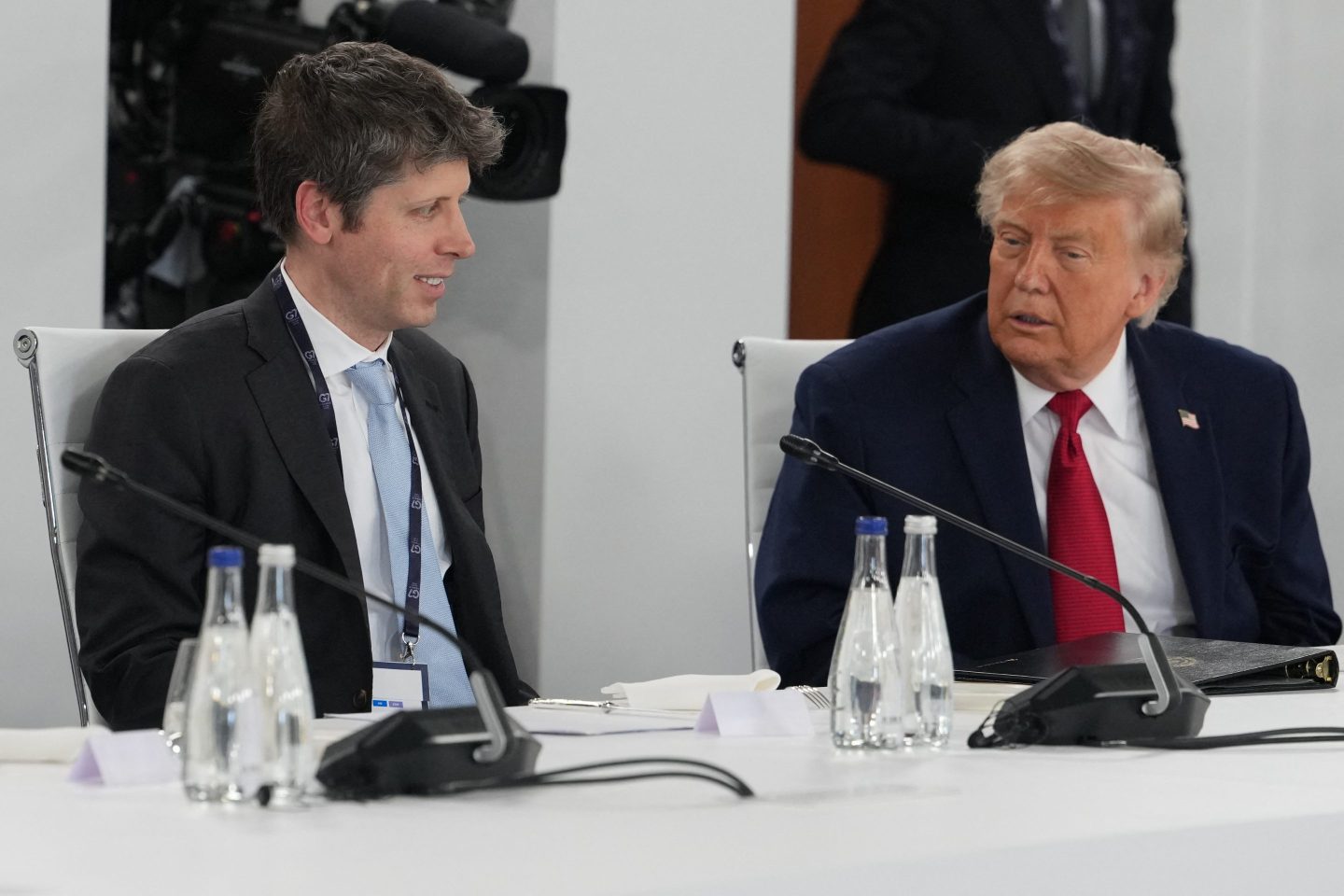 OpenAI CEO Sam Altman sits next to U.S. President Donald Trump.