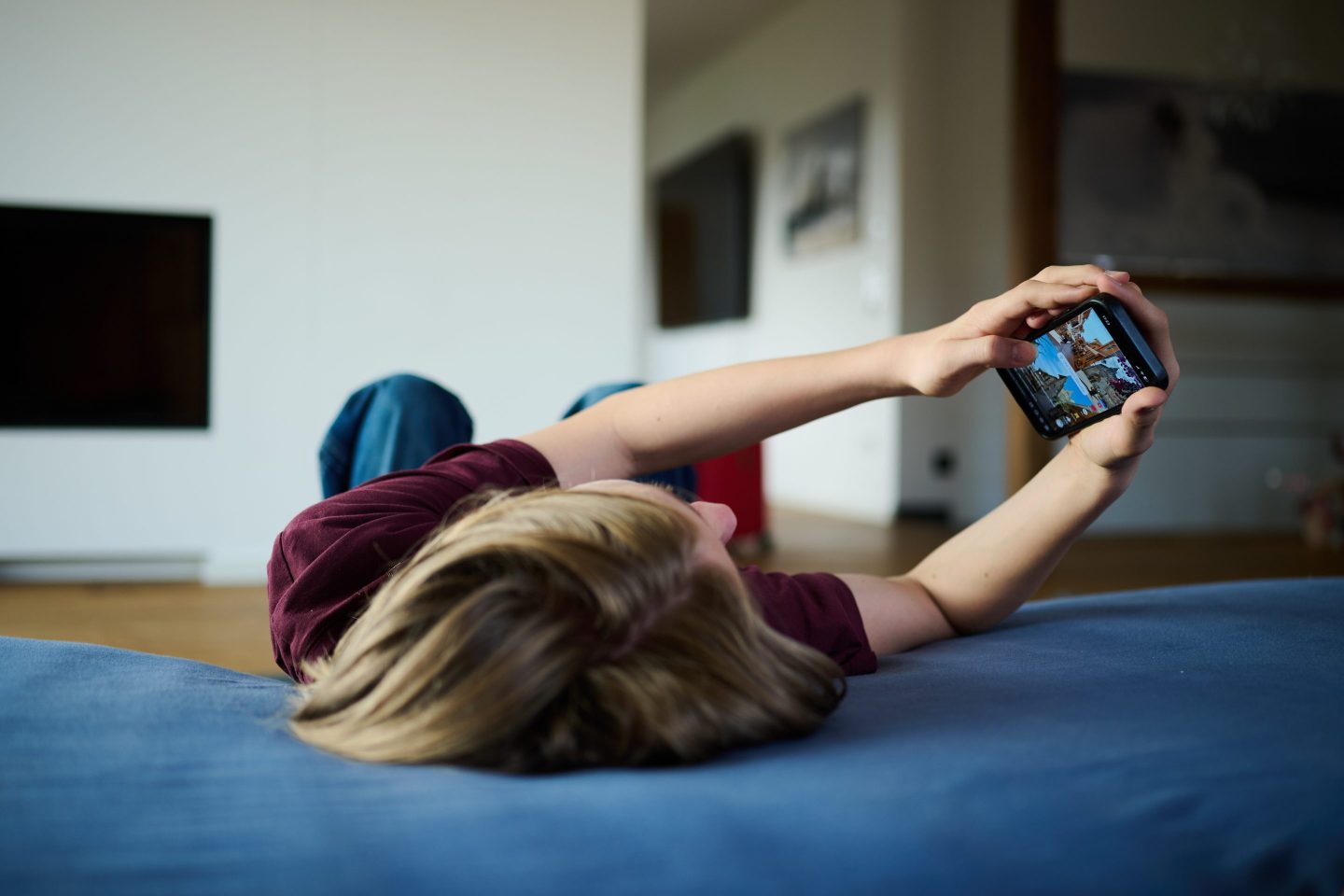 kid lying down on phone