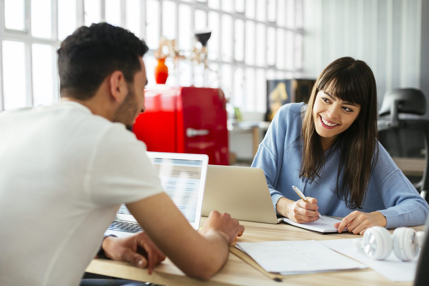Smiling colleagues working at desk in office.