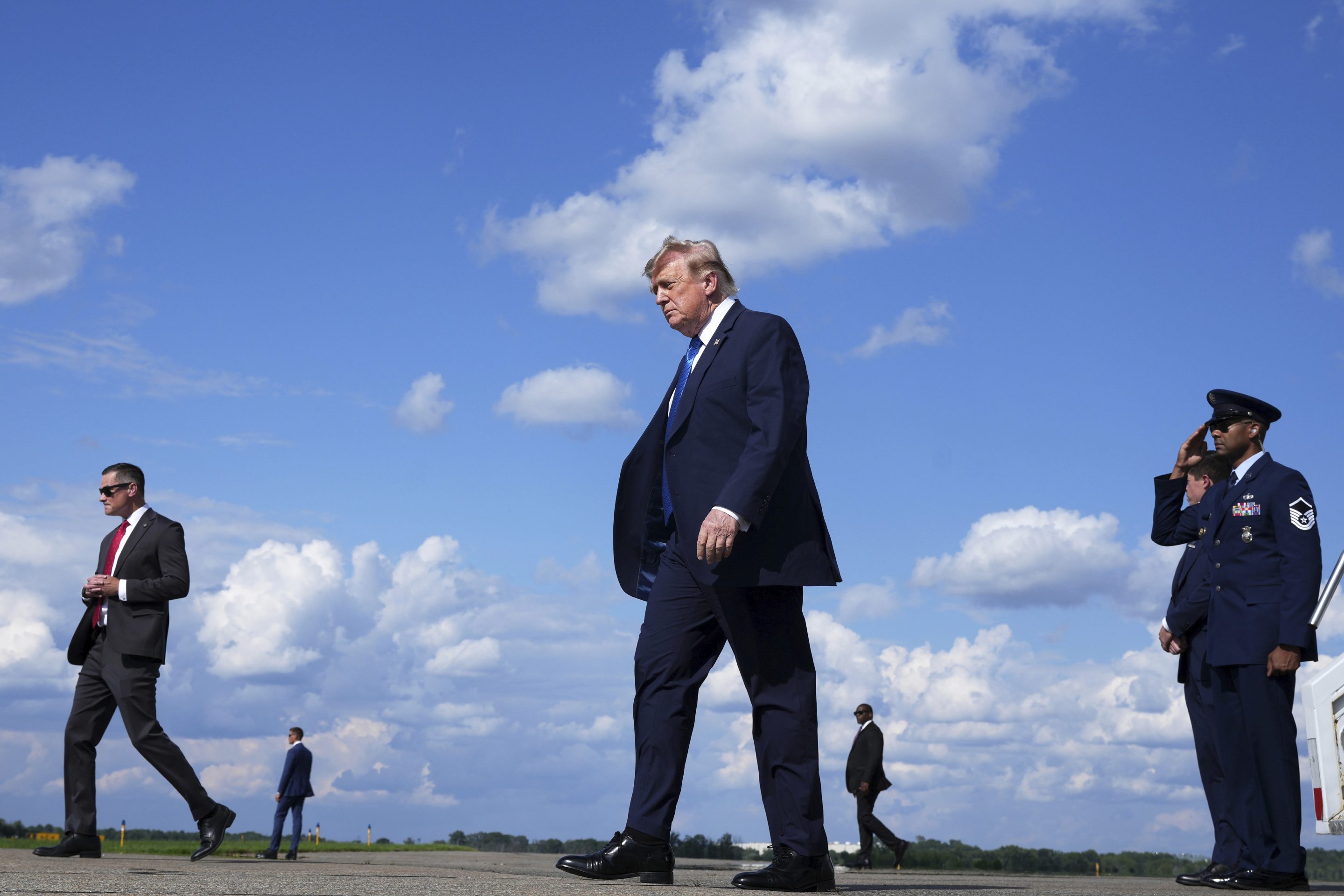 President Donald Trump, center, walks from Air Force One at Morristown Municipal Airport in Morristown, N.J., Friday, July 31, 2026, from Camp David, the presidential retreat.