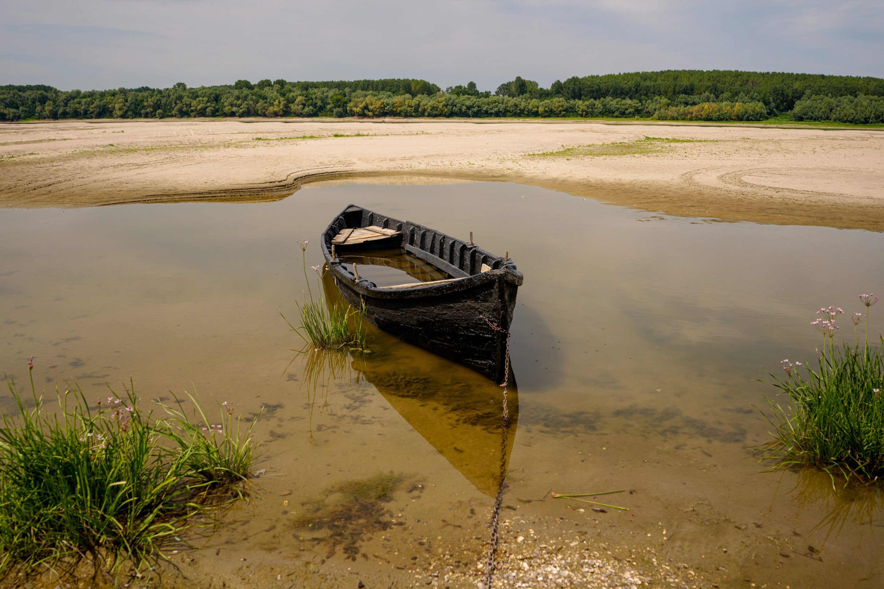 A boat banked on a sand in an area that is usually submerged in the Danube River in Rasova, Romania.